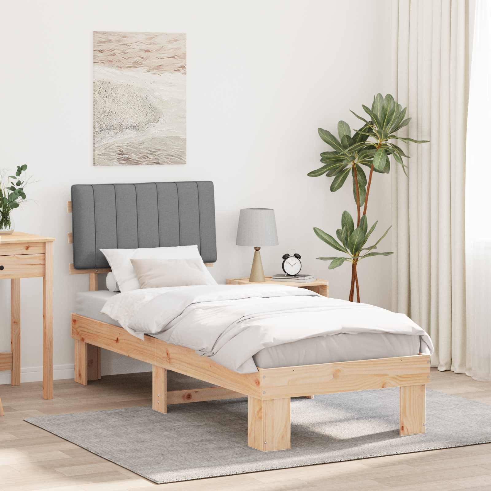 Ein minimalistisches Schlafzimmer zeigt ein Holzbett mit grauer Bettwäsche, einen passenden Nachttisch und eine Pflanze. Ein Landschaftsgemälde hängt darüber.
