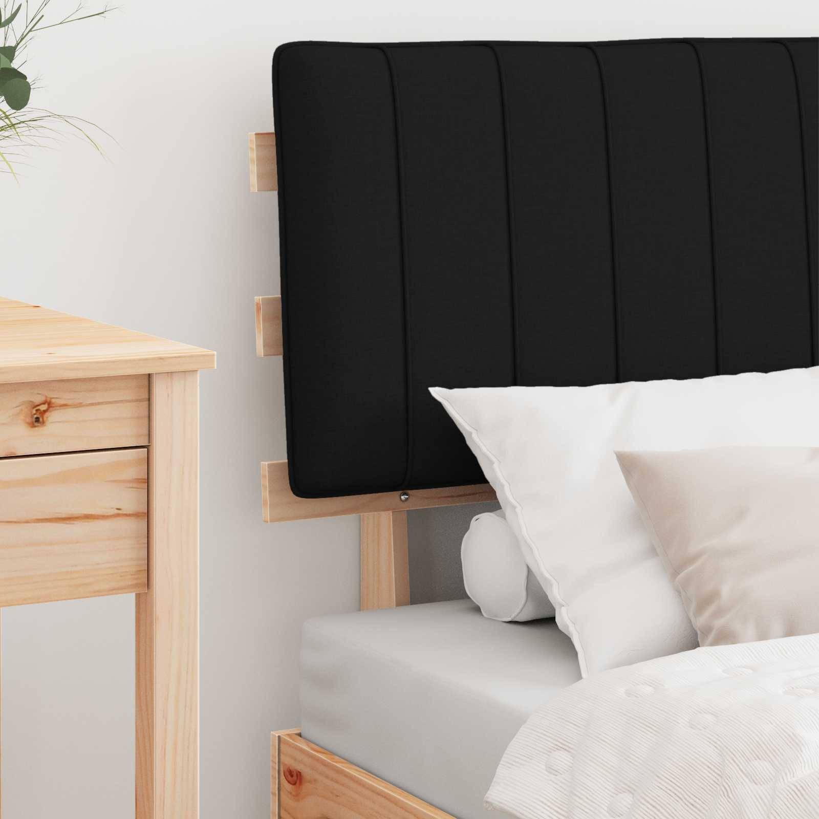 Eine gemütliche Schlafzimmerszene mit einem ordentlich gemachten Bett, weißen Kissen und einem gesteppten Kopfteil. Ein Holznachttisch ist teilweise zu sehen.