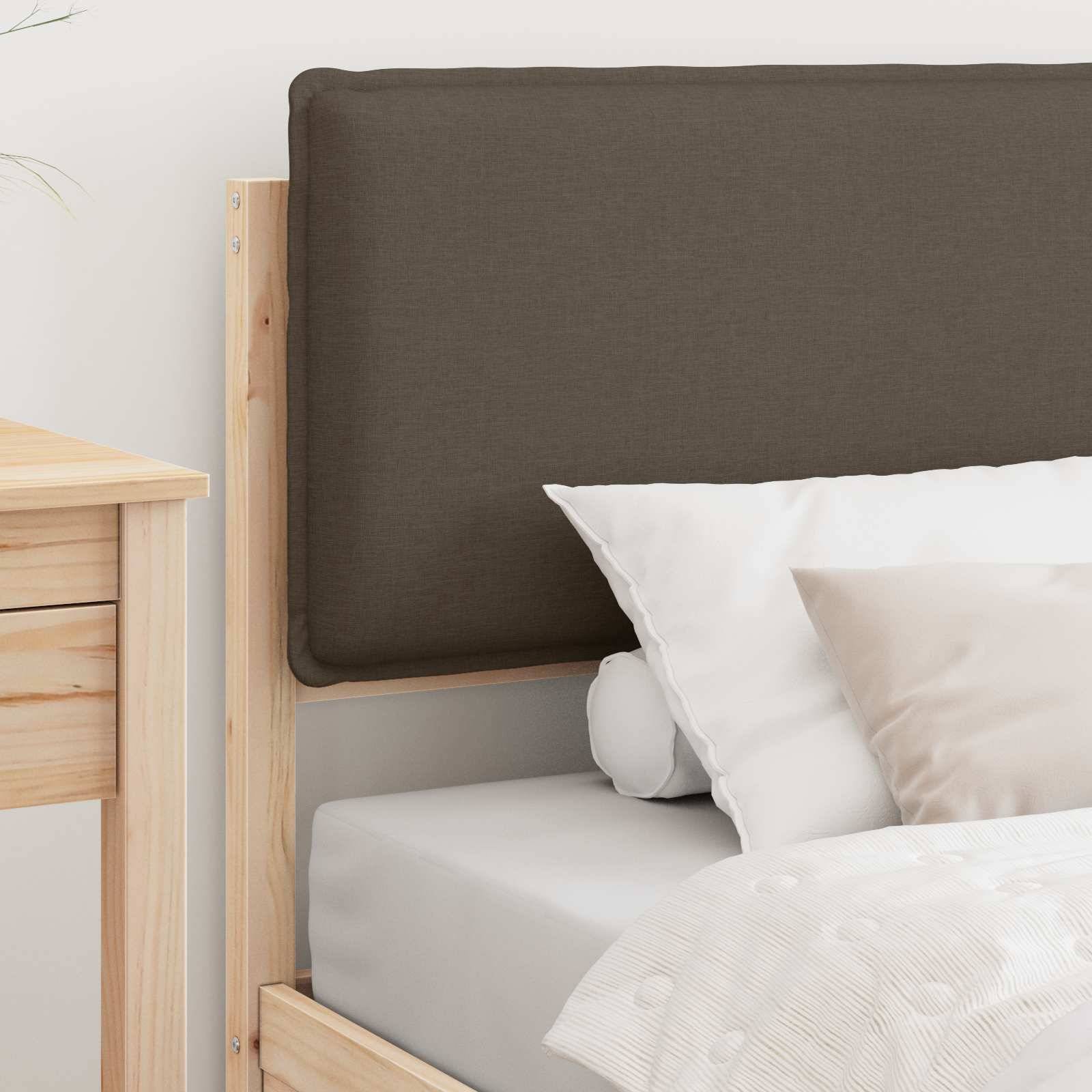 Ein Holzbett mit einer dunkelbraunen gepolsterten Kopfstütze, weißer Bettwäsche und weiß-beigen Kissen, neben einem Holznachttisch.