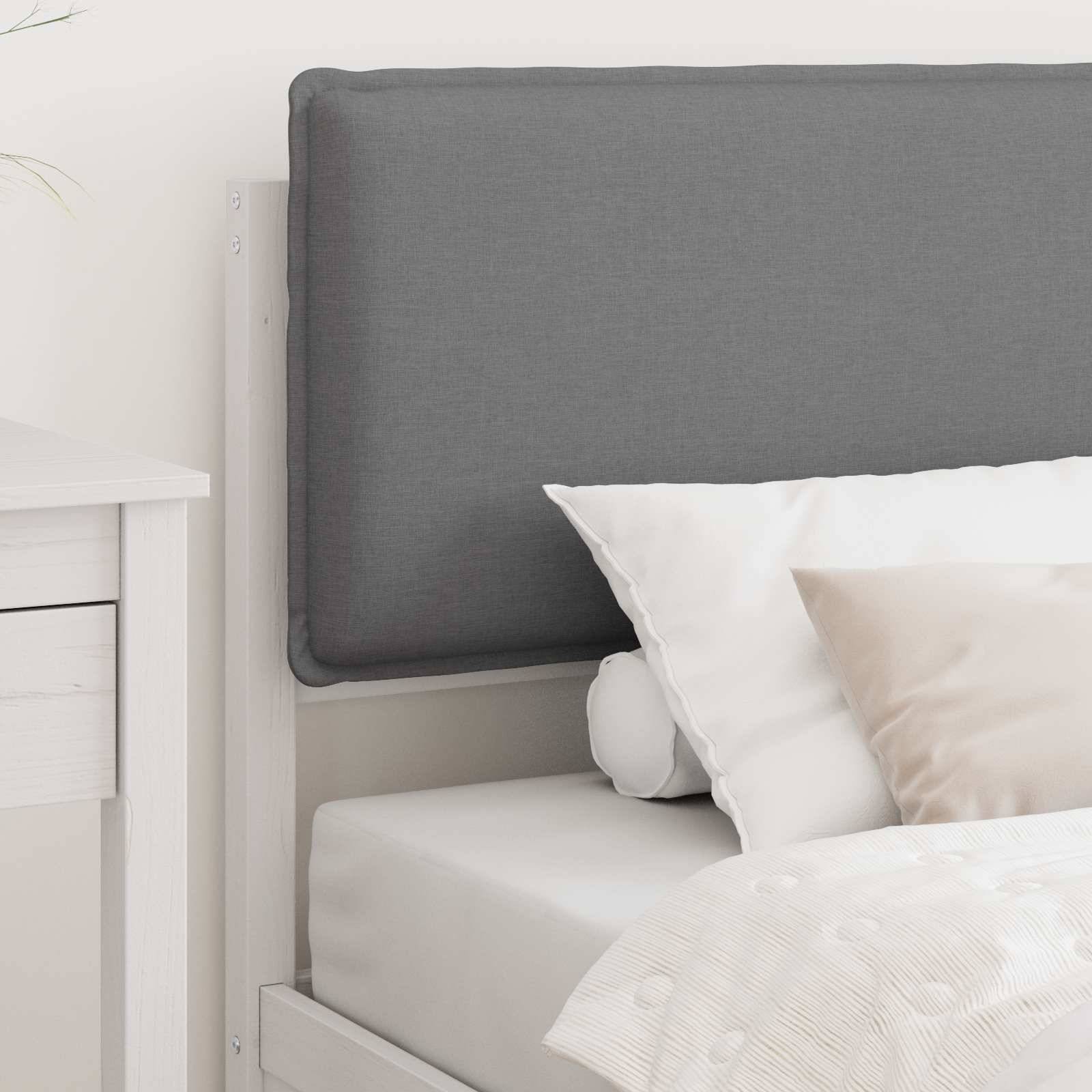 Ein ordentlich gemachtes Bett mit weißem Rahmen und grauem gepolstertem Kopfteil, ausgestattet mit weißer Bettwäsche und einem beigen Akzentkissen, neben einem weißen Nachttisch.