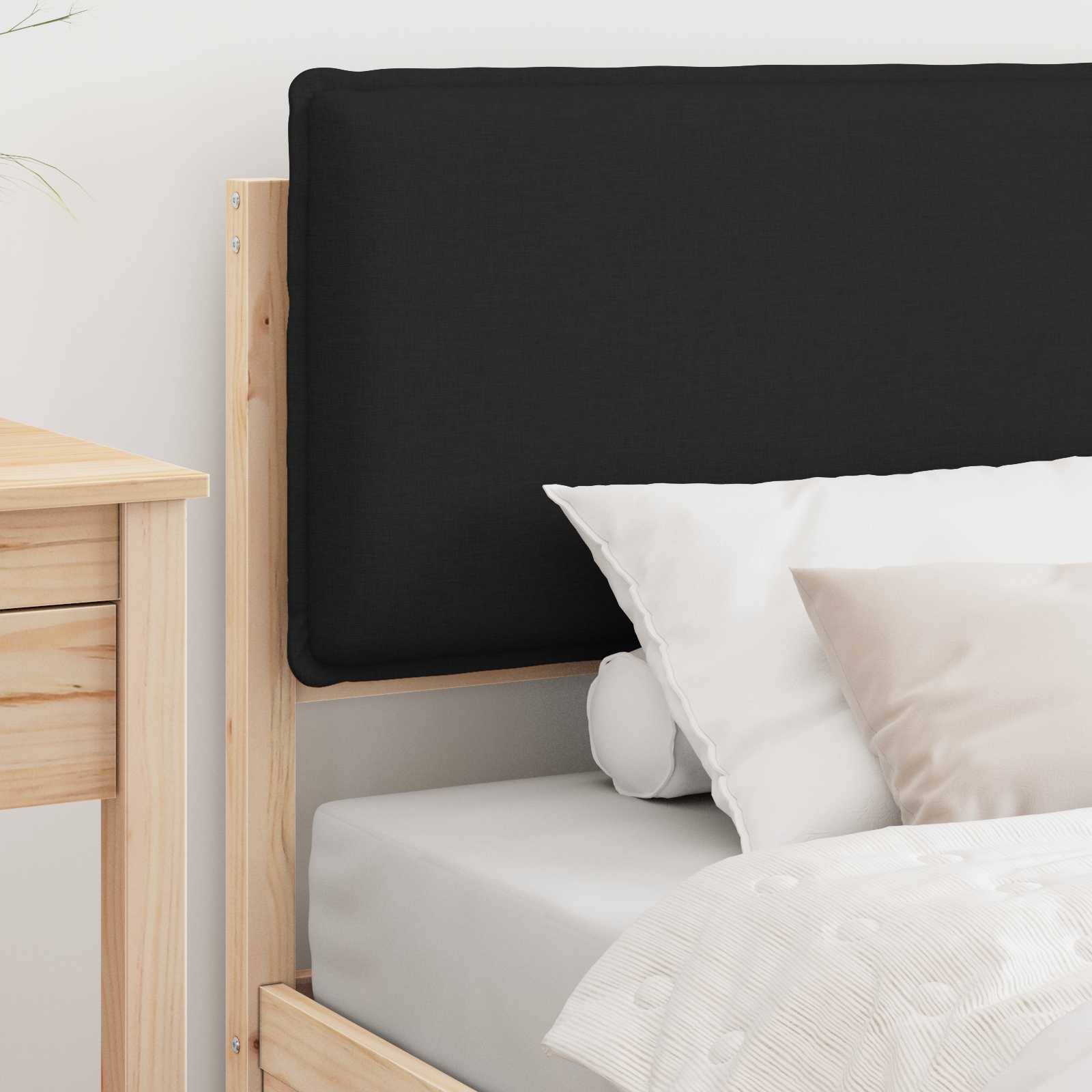 Ein minimalistisches Schlafzimmer zeigt einen hellen Holzbettrahmen mit einem schwarzen Kopfteil und weißer Bettwäsche, neben einem Holznachttisch.