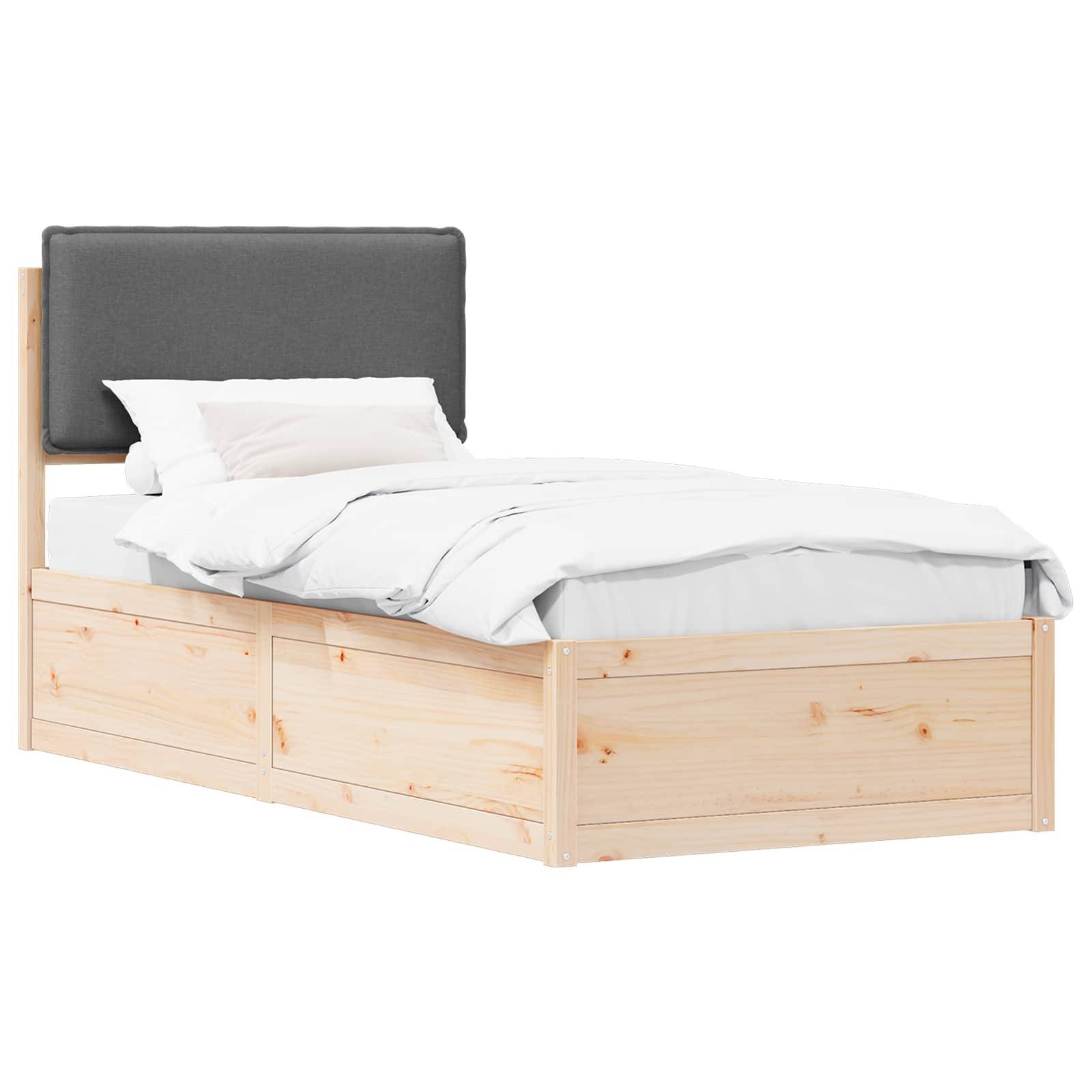 Ein Einzelbett mit hellem Holzrahmen und einem dunkel gepolsterten Kopfteil, bezogen mit weißer Bettwäsche und Kissen, vor einem schlichten Hintergrund.
