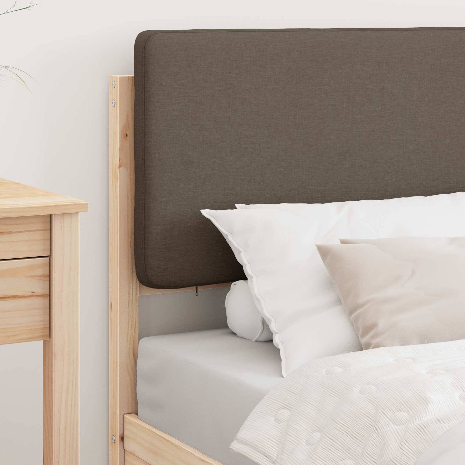 Ein ordentlich gemachtes Bett mit einem braunen Kopfteil, geschmückt mit weißen und beigen Kissen, neben einem Nachttisch aus hellem Holz in einem minimalistischen Schlafzimmer.