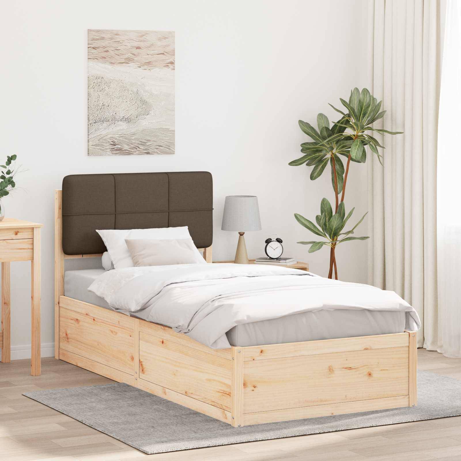 Ein ordentlich eingerichtetes Schlafzimmer mit einem Holzbett, grauer Bettwäsche, einem Holznachttisch mit einer Lampe und einer Uhr sowie einer Topfpflanze neben einem Vorhang.