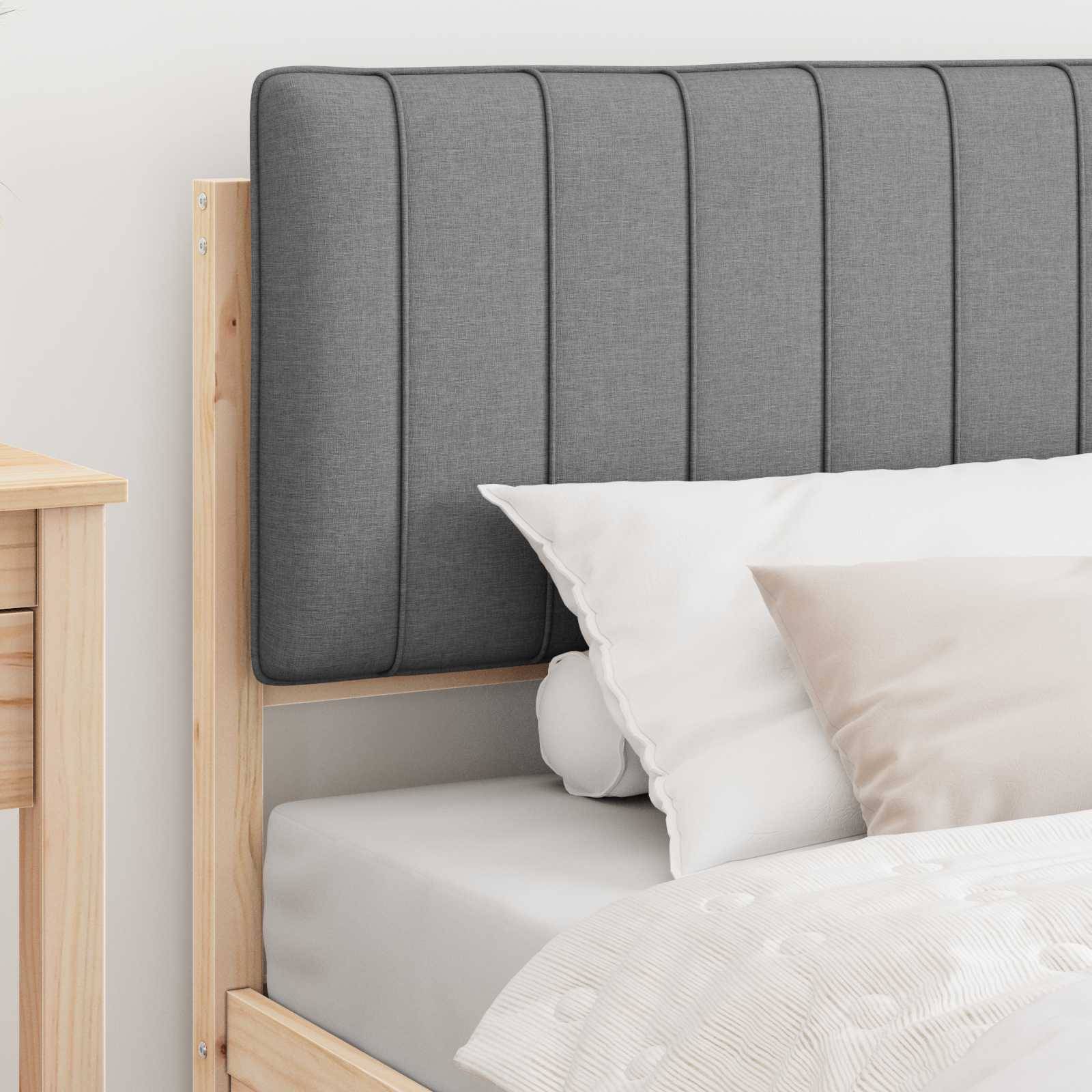 Holzbett mit grau gepolstertem Kopfteil, weiße und beige Kissen, neben einem Holznachttisch. Klares, minimalistisches Schlafzimmerdesign.