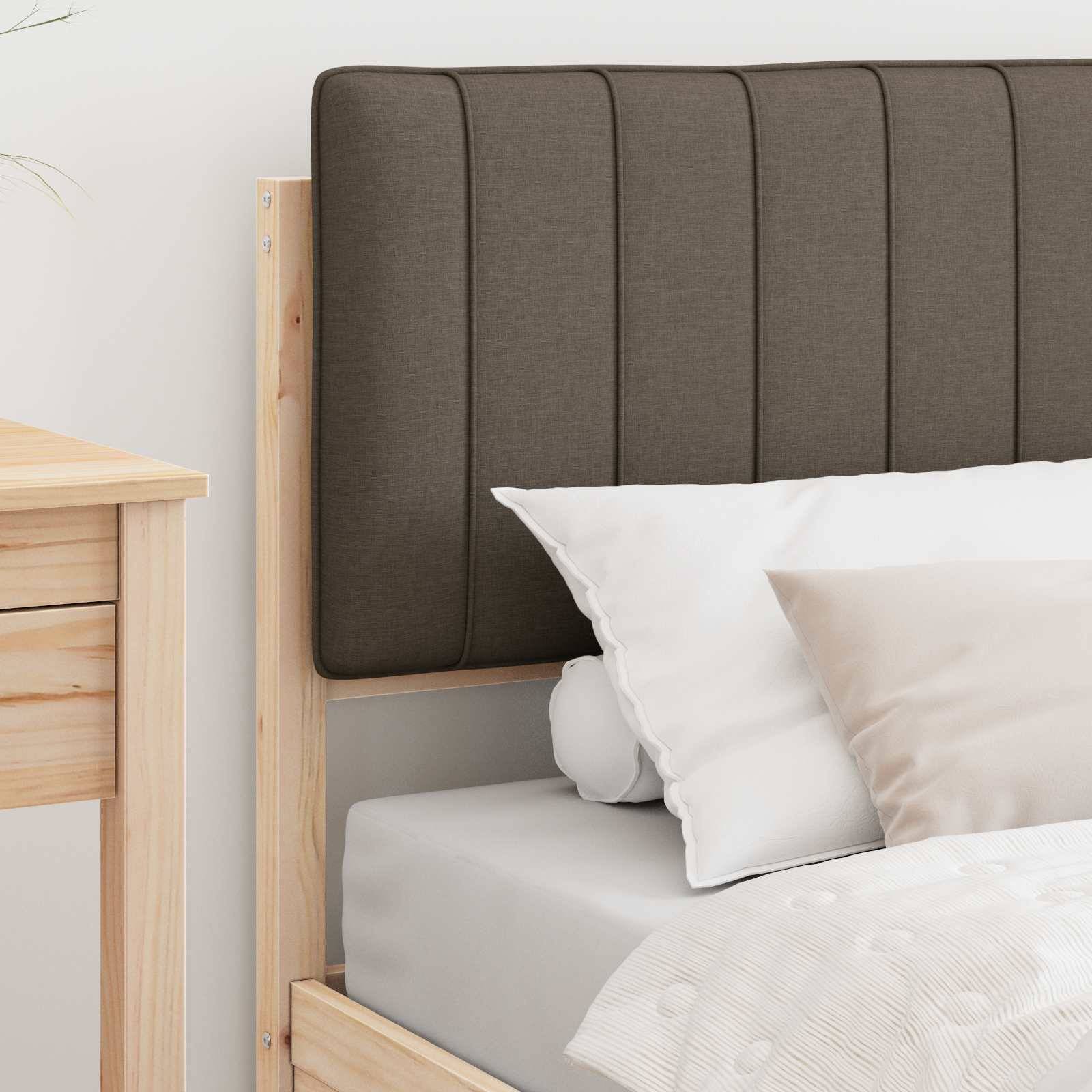 Ein sauber gemachtes Bett mit weißer und beige-farbener Bettwäsche, Holzrahmen und gepolstertem Kopfteil neben einem Holznachttisch.