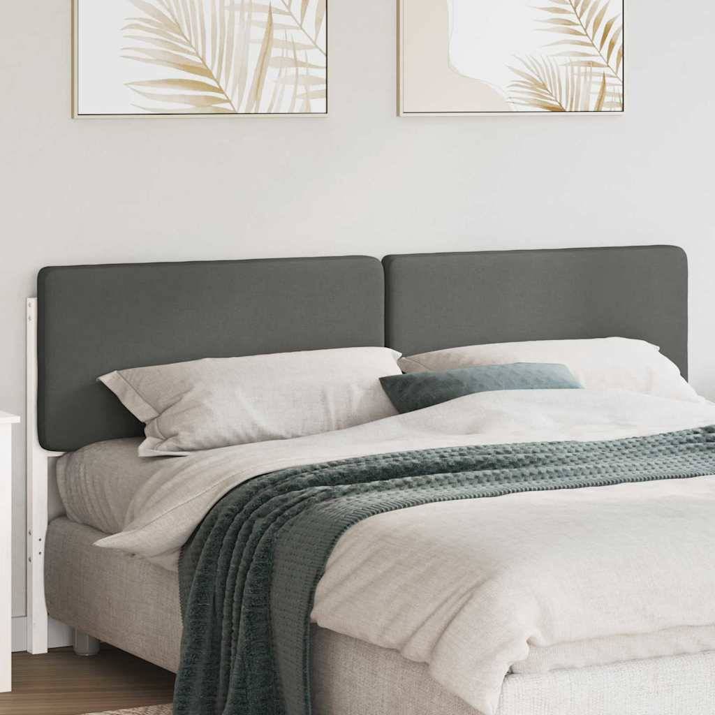 Ein ordentlich gemachtes Bett mit grauen Kissen und einer strukturierten grünen Decke, eingebettet in ein minimalistisches Schlafzimmer mit zwei abstrakten Kunstwerken über dem Kopfteil.