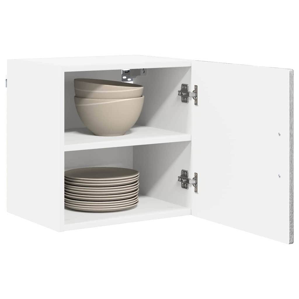 Geöffneter weißer Küchenschrank mit zwei Regalen; oberes Regal enthält beige Schüsseln, die sich in einer größeren befinden; unteres Regal trägt gestapelte beige Teller.
