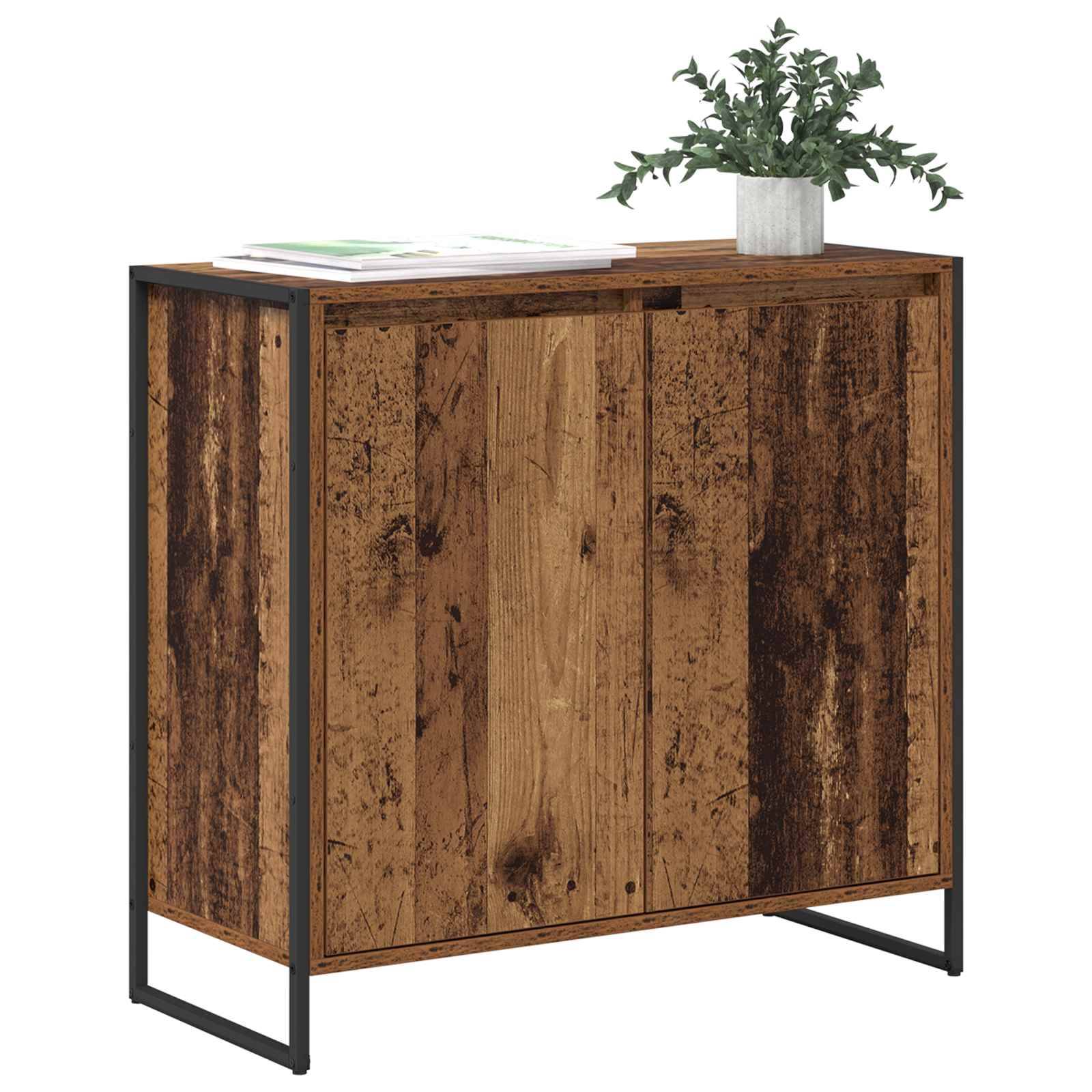 Ein Holzschrank mit rustikaler Oberfläche, zwei Türen und schwarzem Metallrahmen. Eine grüne Topfpflanze und offene Broschüren stehen obendrauf.