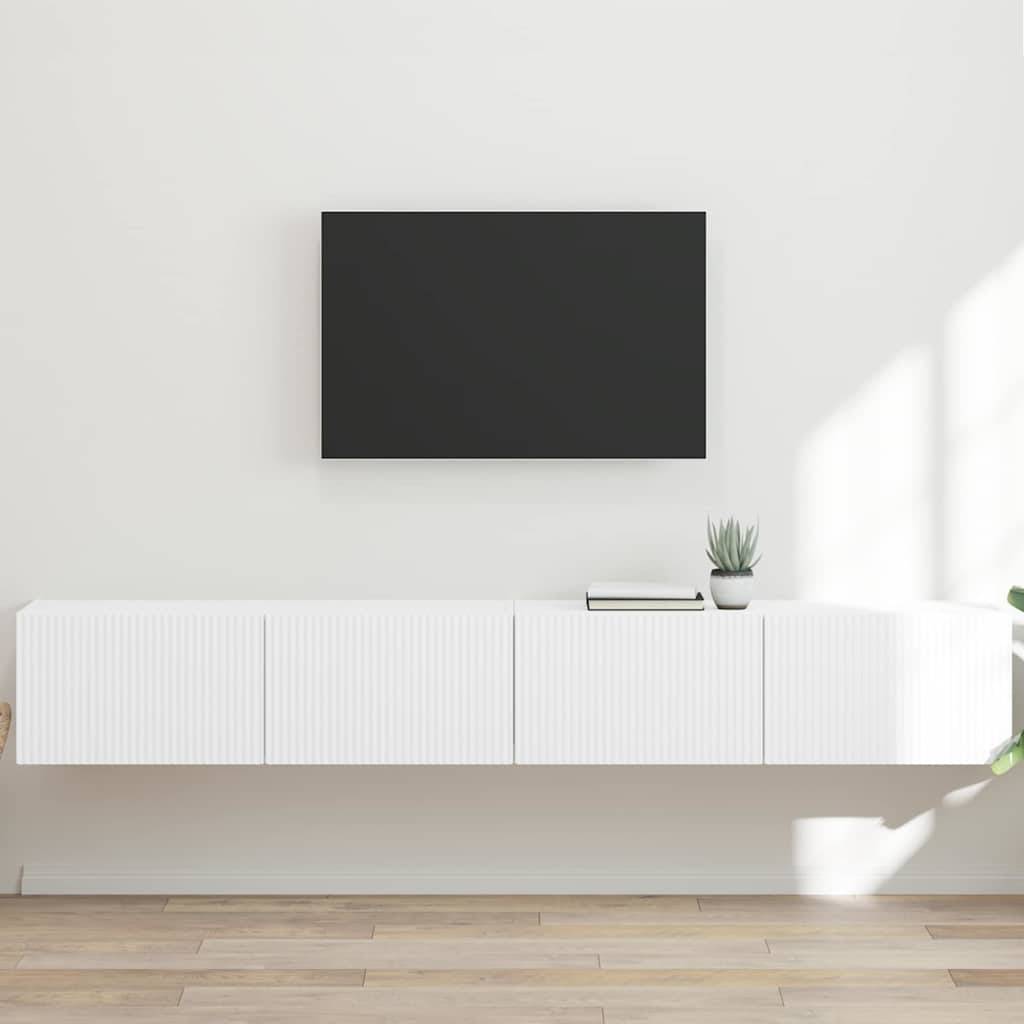 Ein minimalistisches Wohnzimmer mit einem wandmontierten Flachbild-Fernseher über einem weißen schwebenden Schrank. Eine kleine Pflanze und ein Buch liegen auf dem Schrank.