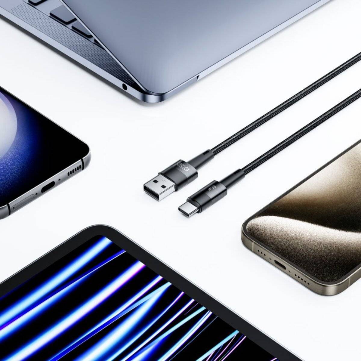 Eine Nahaufnahme verschiedener elektronischer Geräte und Ladegeräte, einschließlich eines Laptops, Tablets, Smartphones und zwei USB-Kabel auf einer weißen Oberfläche.