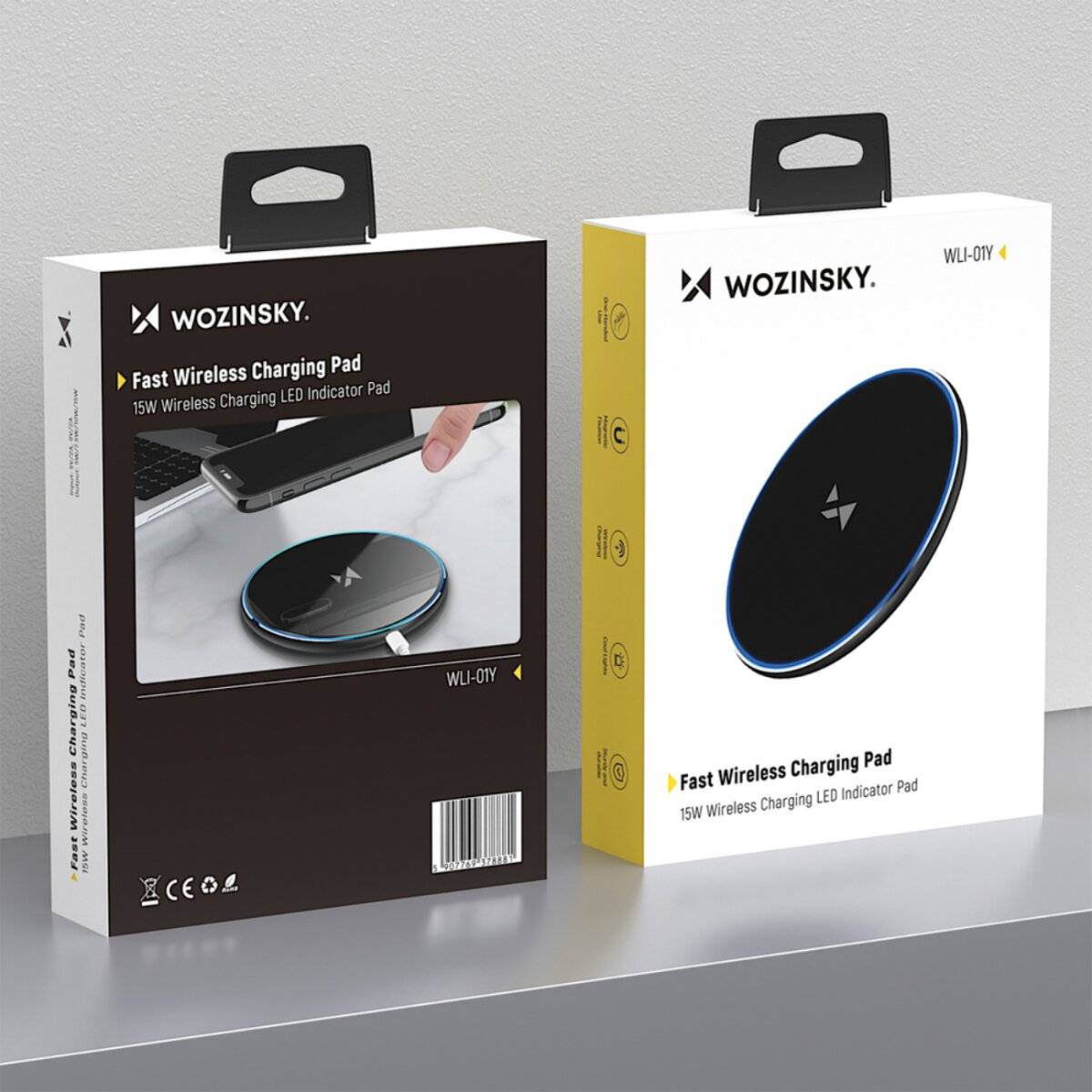 Zwei Boxen des Wozinsky Fast Wireless Charging Pad mit einer 15W-Kapazität werden auf einer grauen Oberfläche präsentiert. Die Verpackung zeigt Produktbilder und Spezifikationen.