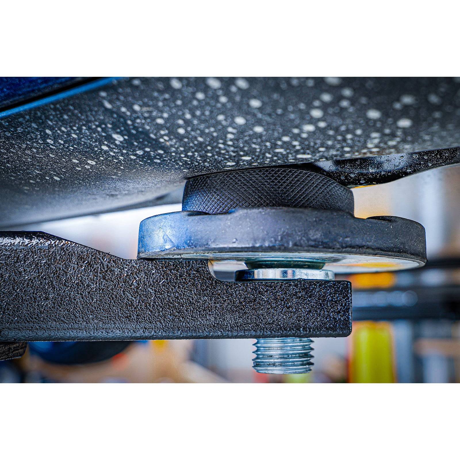 Eine Nahaufnahme eines Autohebevorrichtungs-Pads unter einem Fahrzeug, das das Pad zeigt, das sicher gegen die Unterseite des Fahrzeugs positioniert ist, mit einem Bolzen.