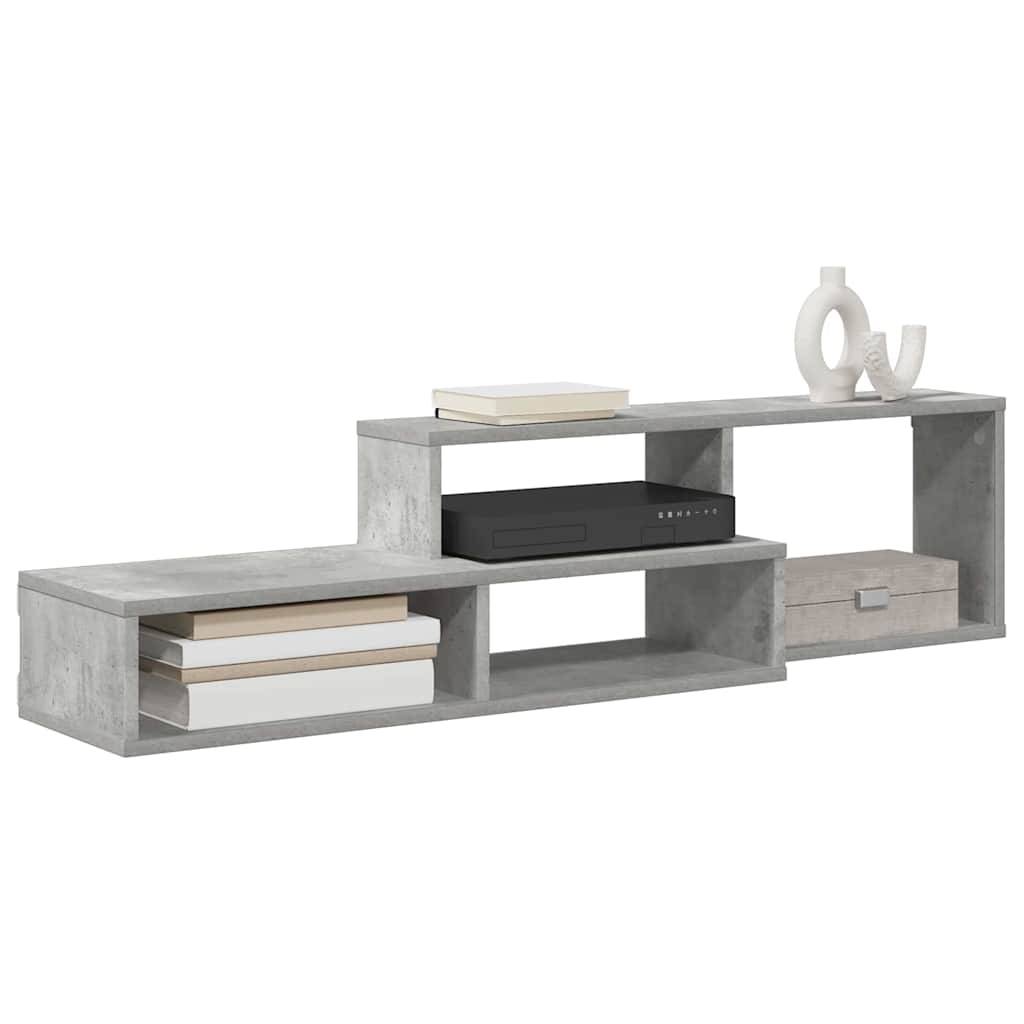 Niedriger TV-Ständer aus Beton mit drei offenen Regalen und Dekorationselementen, darunter Bücher, eine Box, ein schwarzes Gerät und eine weiße Skulptur.
