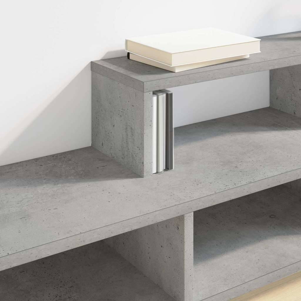 Ein minimalistisches Bücherregal aus Beton mit einigen Büchern und einem geschlossenen Notizbuch auf dem obersten Regal, was auf einen modernen, aufgeräumten Arbeitsbereich hindeutet.