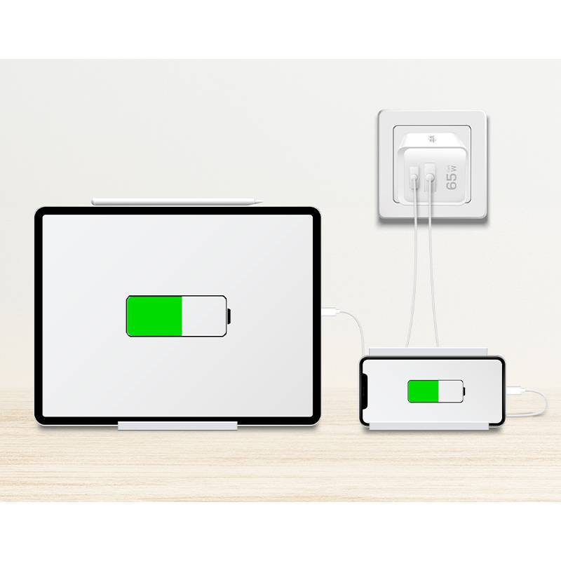 Ein Tablet und ein Smartphone, die auf einer hellen Holzoberfläche geladen werden. Der Bildschirm des Tablets zeigt eine große, teilweise gefüllte grüne Batteriesymbol.