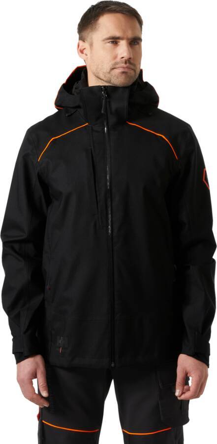 Mann, der eine schwarze Jacke mit Kapuze und passende Hose mit orangefarbenem Besatz trägt, frontal vor weißem Hintergrund gezeigt.