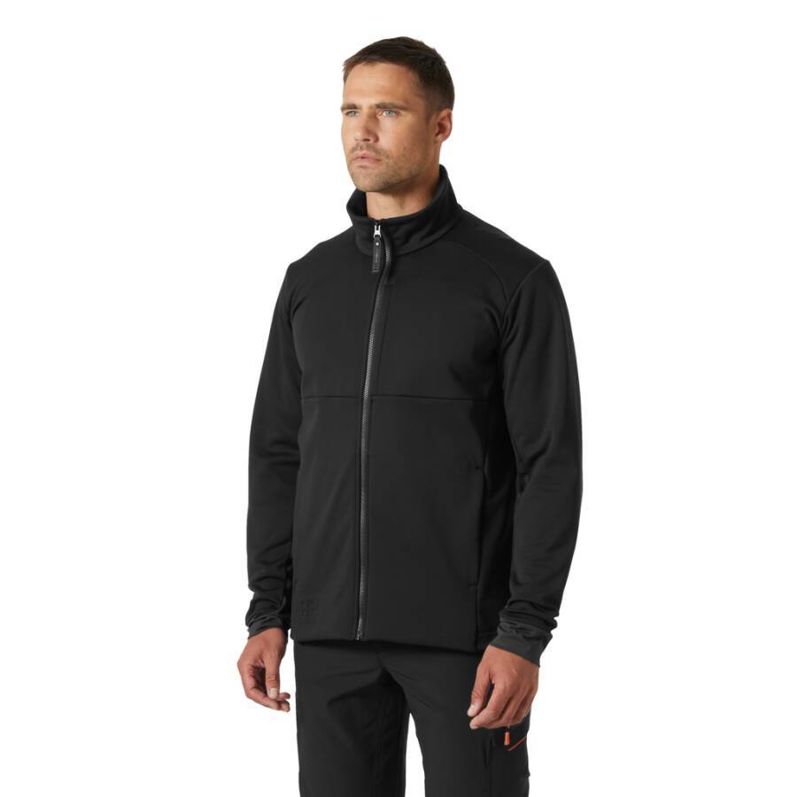 Ein Mann mit einer schwarzen Reißverschlussjacke steht vor einem schlichten weißen Hintergrund und blickt neutral zur Seite.