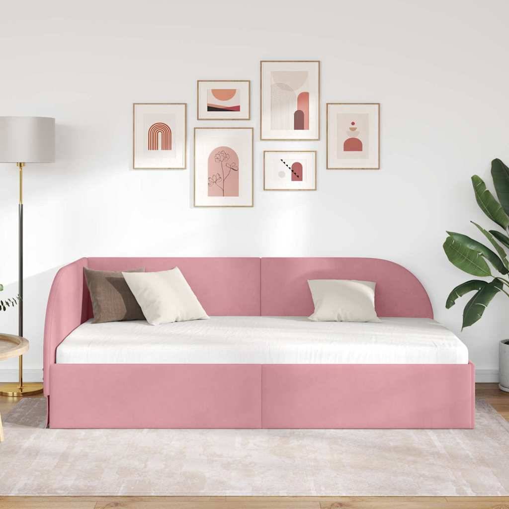 Ein rosa Tagesbett mit weißen und beige Kissen steht in einem modernen Wohnzimmer, das mit einer Galeriewand aus abstrakter Kunst und einer Topfpflanze geschmückt ist.