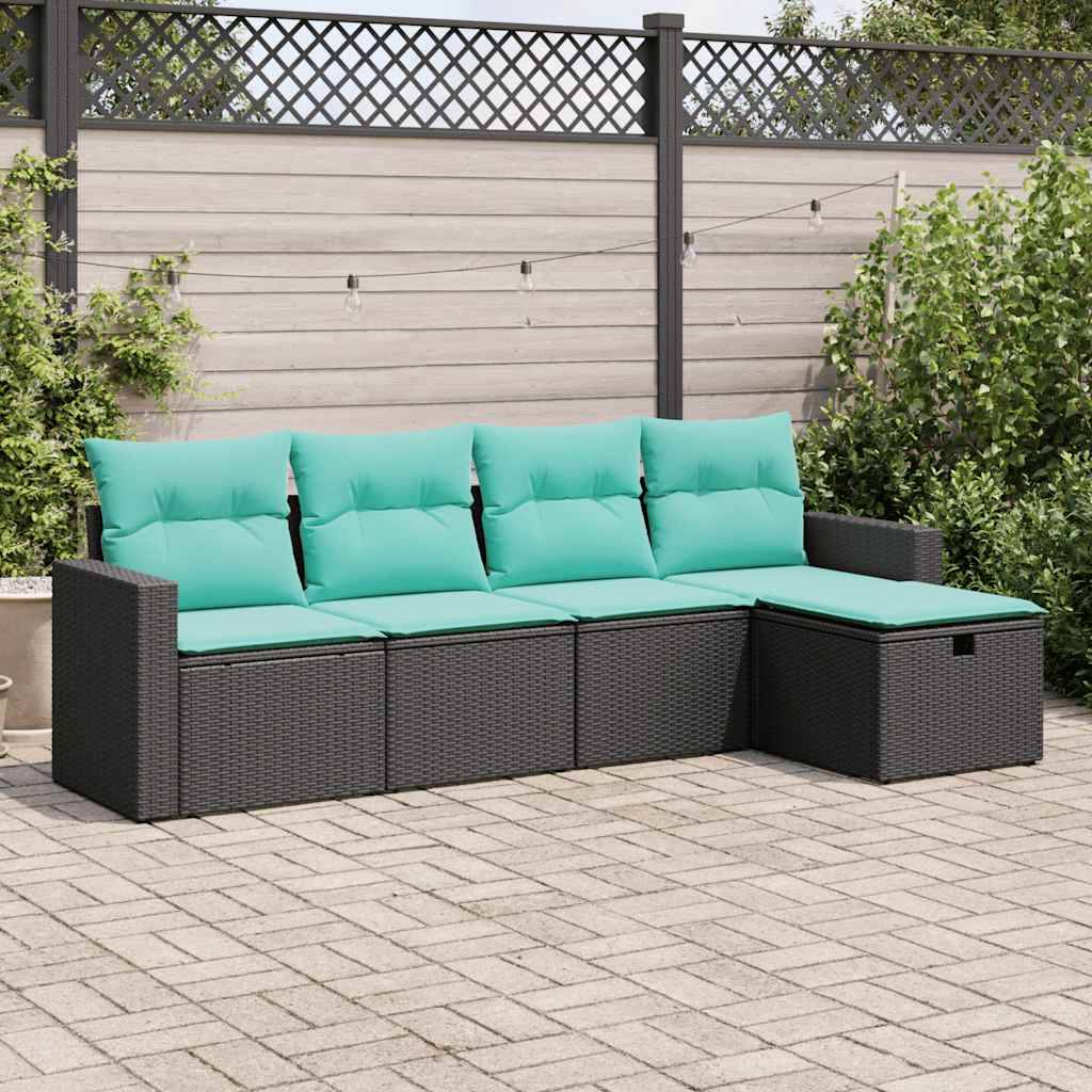 Eine Flechtwerk-Terrassencouch mit türkisfarbenen Kissen steht auf einer gepflasterten Außenfläche, im Rücken von einem Holz-Sichtschutzzaun und Grünpflanzen.