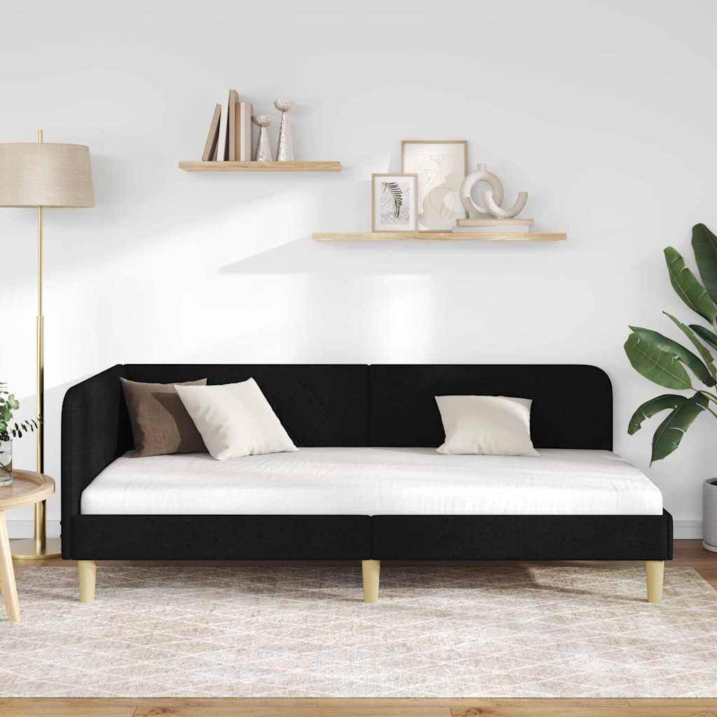 Ein moderner Wohnraum präsentiert ein schwarzes und weißes Sofa, dekorative Kissen, zwei Holzregale mit Kunstobjekten und eine Topfpflanze.