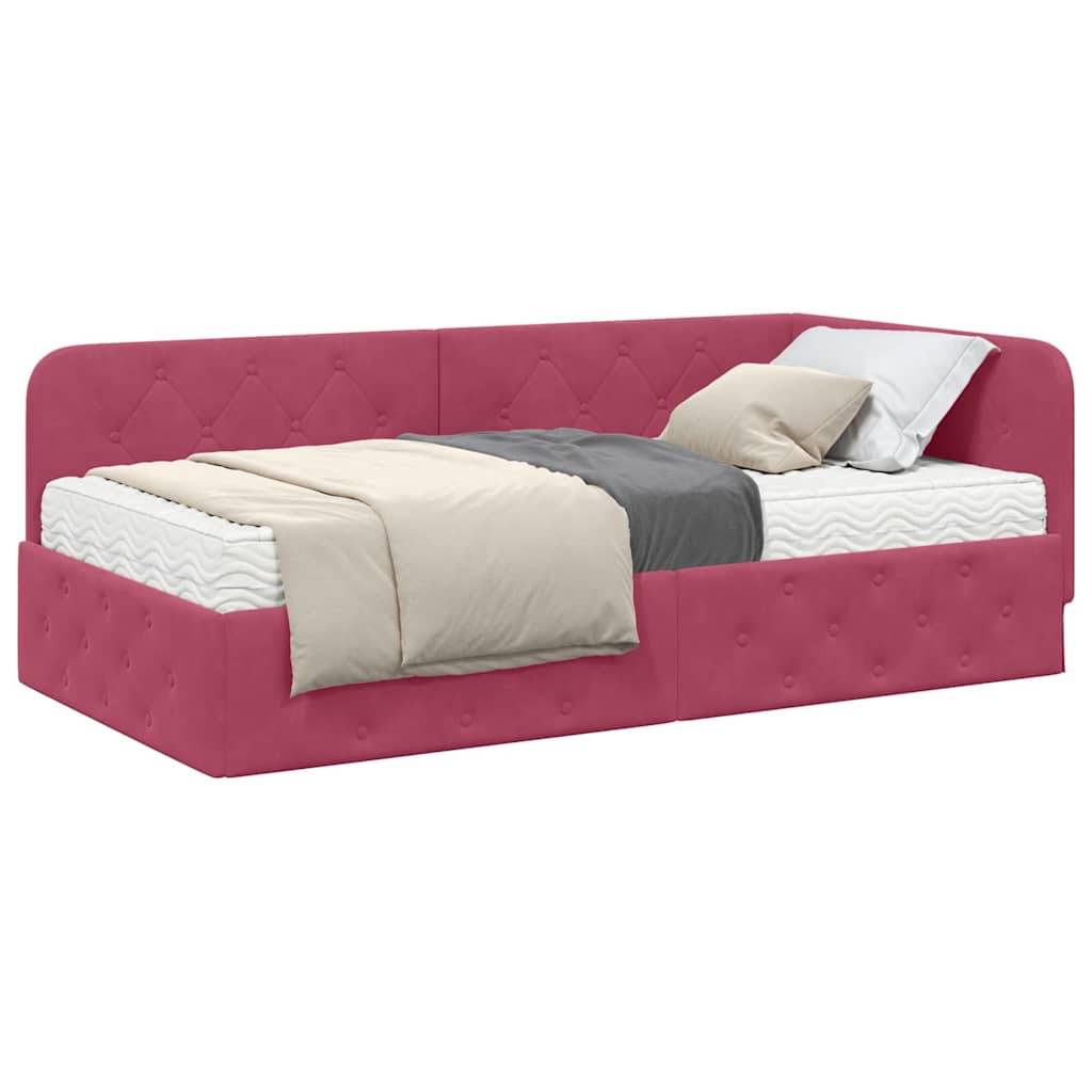 Ein rosa gepolstertes Tagesbett wird mit einem grau-weißen Bettwäsche-Set präsentiert, inklusive Kissen und einer zusammengelegten Decke, was eine gemütliche Atmosphäre vermittelt.