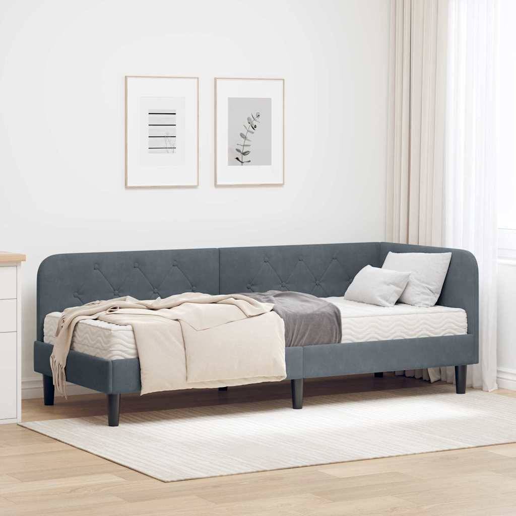 Ein stilvoller grauer Schlafsofa mit Kissen und einer beigen Decke, platziert in einem hellen, luftigen Raum mit gerahmter Kunst an der Wand und einem kleinen Teppich.