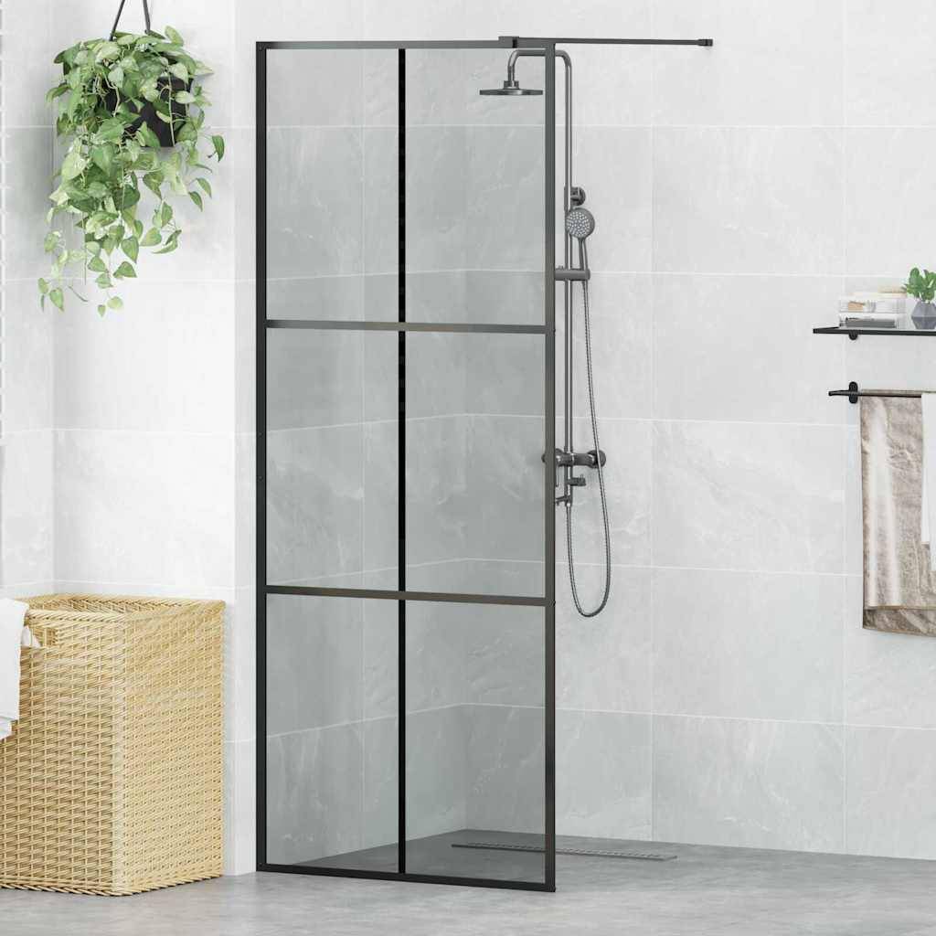 Modernes Badezimmer mit einer Dusche mit Glaspaneel, einer hängenden Pflanze und einem Flechtkorb auf einem gefliesten grauen Boden.