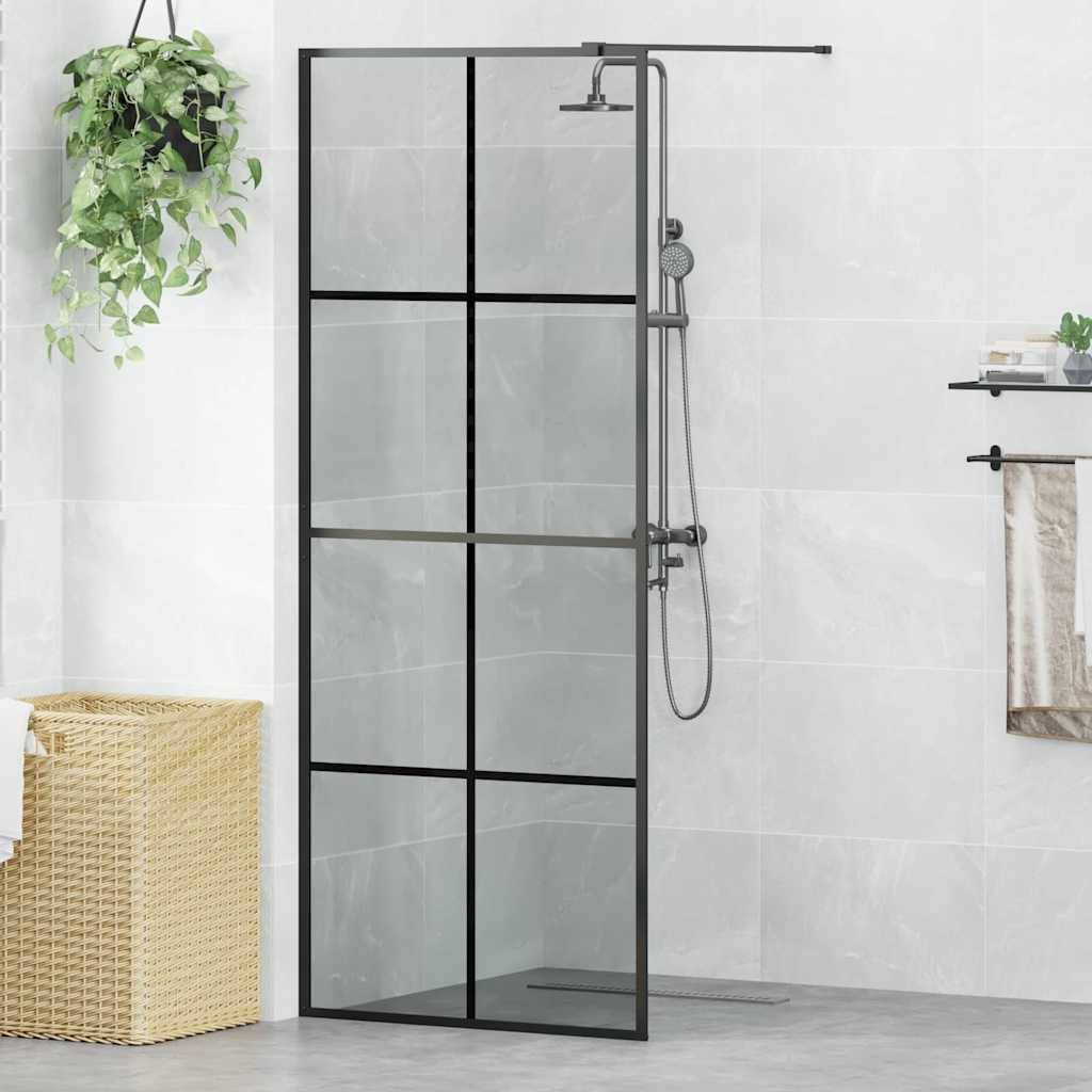 Ein modernes Badezimmer mit einer Dusche, die eine schwarz gerahmte Glastür aufweist, ein Regal mit Toilettenartikel, eine hängende Pflanze und einen Korb aus Rattan.