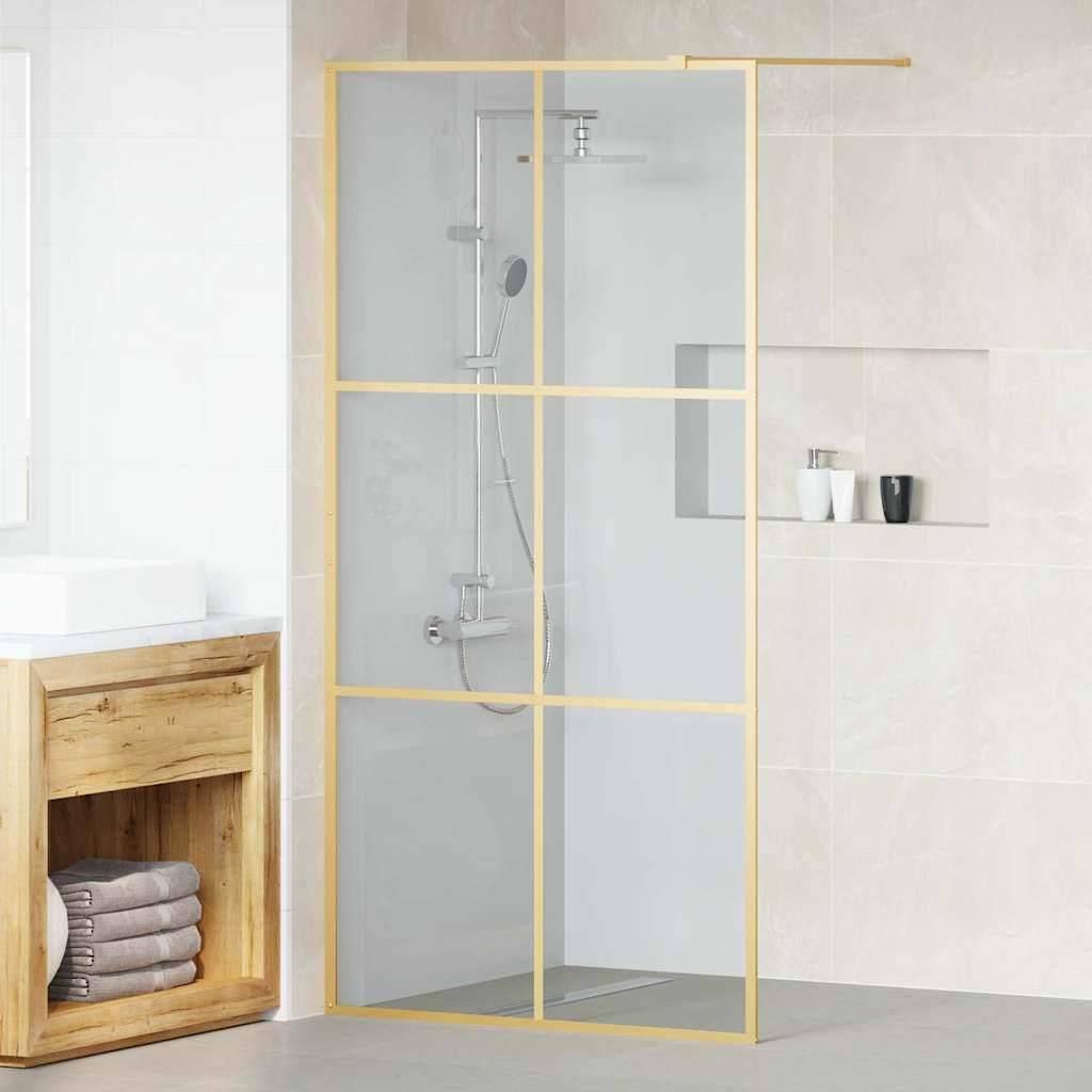 Ein modernes Badezimmer verfügt über eine Glasdusche mit goldenem Rahmen, einer an der Wand montierten Duschbrause und einem Holzwaschbeckenunterschrank mit zusammengelegten Handtüchern darunter.