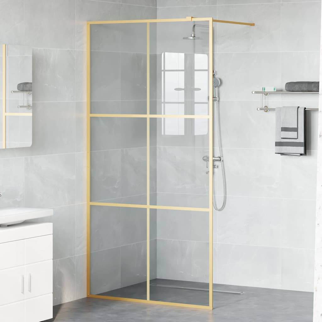 Ein modernes Badezimmer verfügt über eine Glasdusche mit goldener Einfassung, einen weißen Waschtisch mit Spiegel und ordentlich gestapelte Handtücher auf Regalen.
