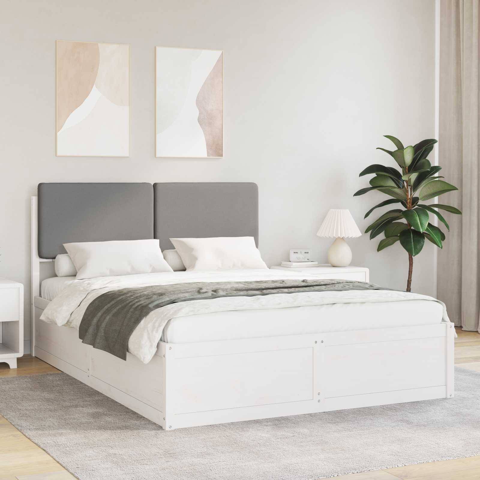 Ein modernes Schlafzimmer präsentiert ein großes Bett mit grauen Kopfteilen, grüner und weißer Bettwäsche, einer Zimmerpflanze und zwei abstrakten Gemälden an der Wand.
