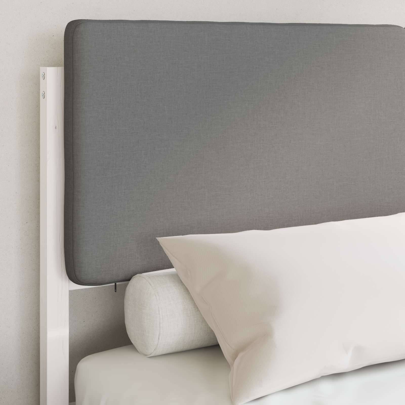Ein Bett mit einem grauen Kopfteil, weißem Kissen und Nackenrolle, das an einer hellgefärbten Wand platziert ist und ein minimalistisches Schlafzimmerdesign bietet.
