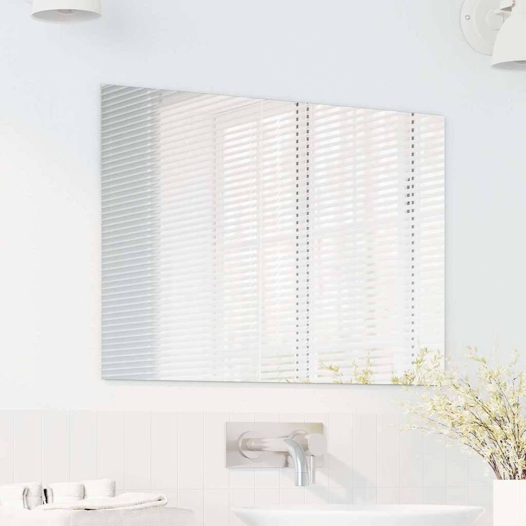 Ein modernes Badezimmer mit einem an der Wand befestigten rechteckigen Spiegel über einem weißen Waschbecken, wobei eine kleine Pflanze der minimalistischen Einrichtung eine grüne Note verleiht.