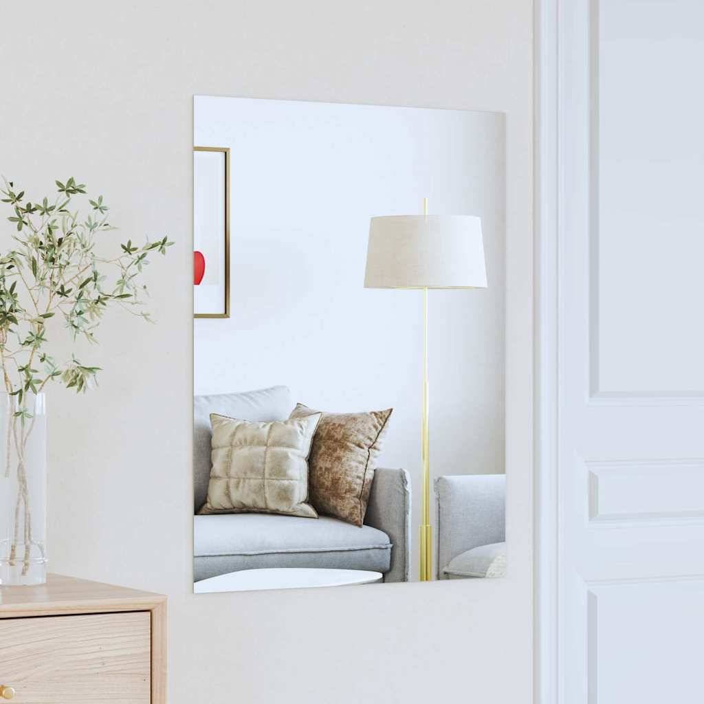 Ein modernes Wohnzimmer spiegelt sich in einem Spiegel und zeigt ein graues Sofa mit beige- und goldfarbenen Kissen, eine goldene Lampe und eine Pflanze in einer Vase.