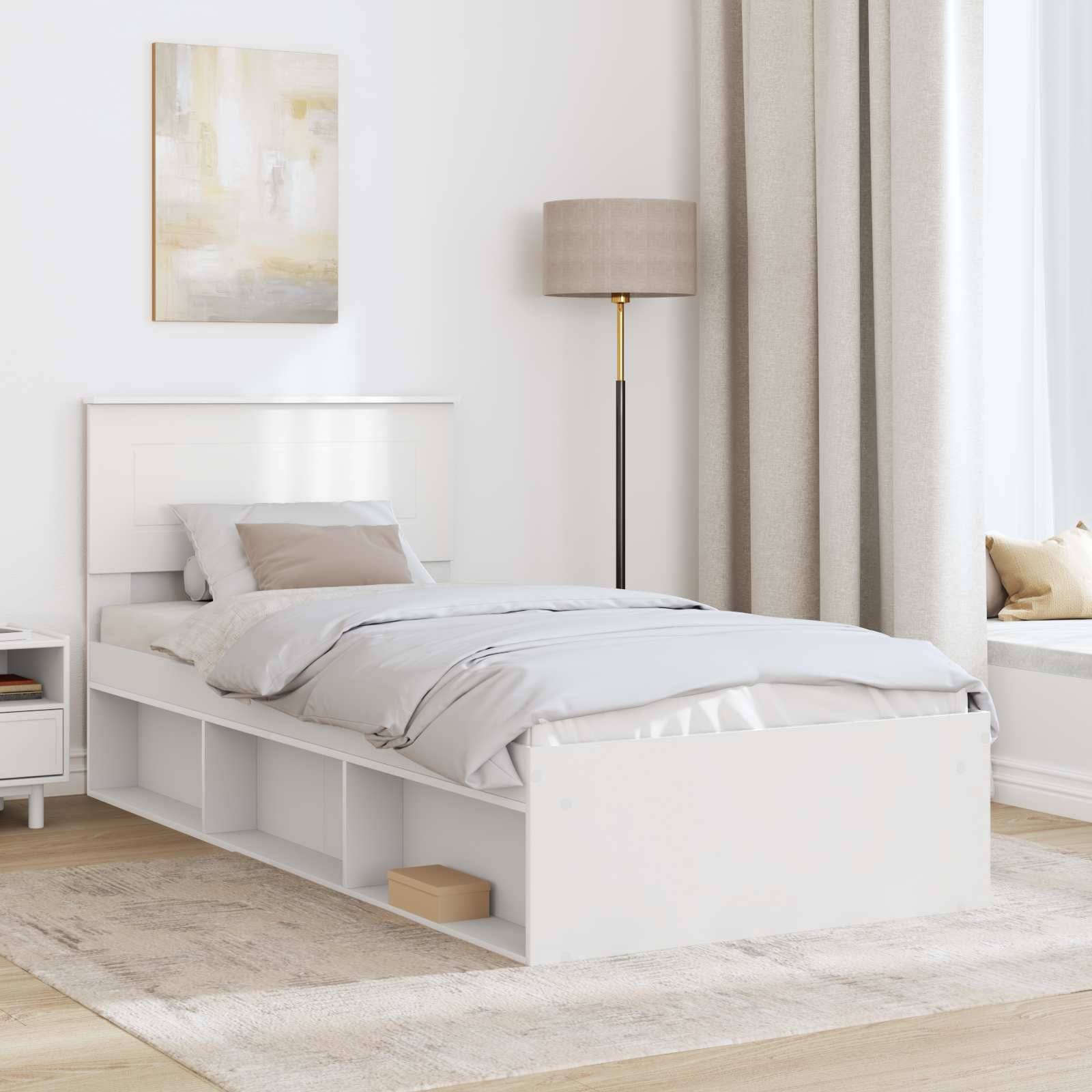 Ein modernes, minimalistisches Schlafzimmer mit einem weißen Bett mit integriertem Stauraum, einer beigen Lampe, einem kleinen Nachttisch und einem großen, mit Vorhängen verhangenen Fenster.