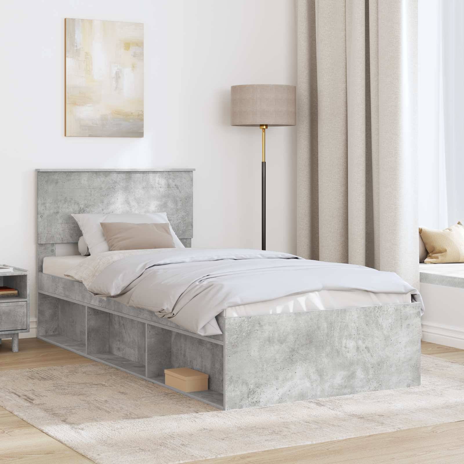 Ein modernes Schlafzimmer mit einem einzelnen grauen Bett mit Stauraum unter dem Bett, beigefarbener Bettwäsche, einem Nachttisch und einer hohen Lampe.