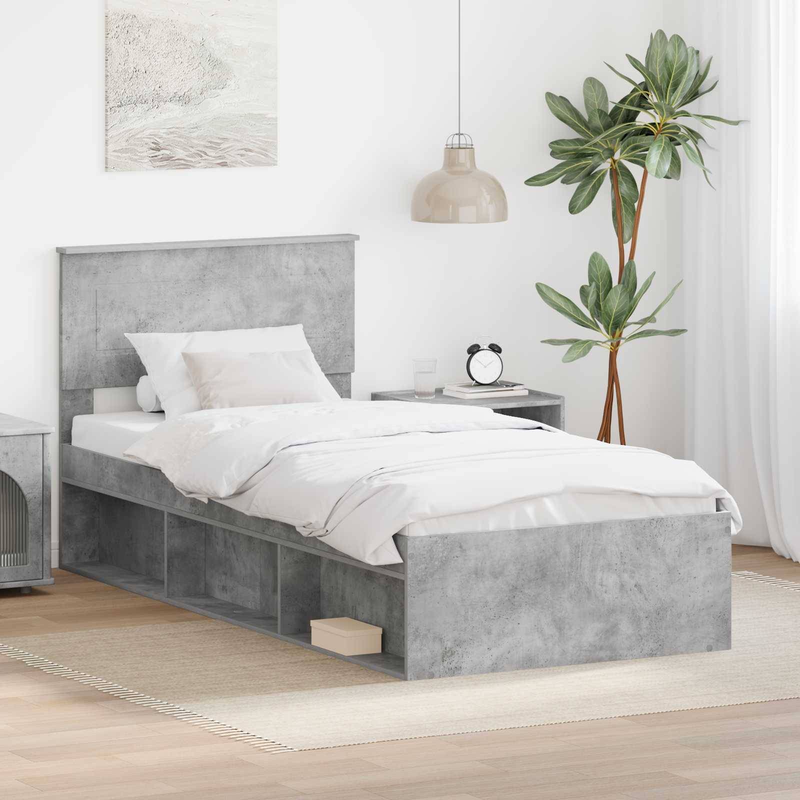 Ein minimalistisches Schlafzimmer mit einem grauen Bett mit Aufbewahrungsschubladen, weißer Bettwäsche, einem Nachttisch, einem Gemälde an der Wand und einer Topfpflanze.