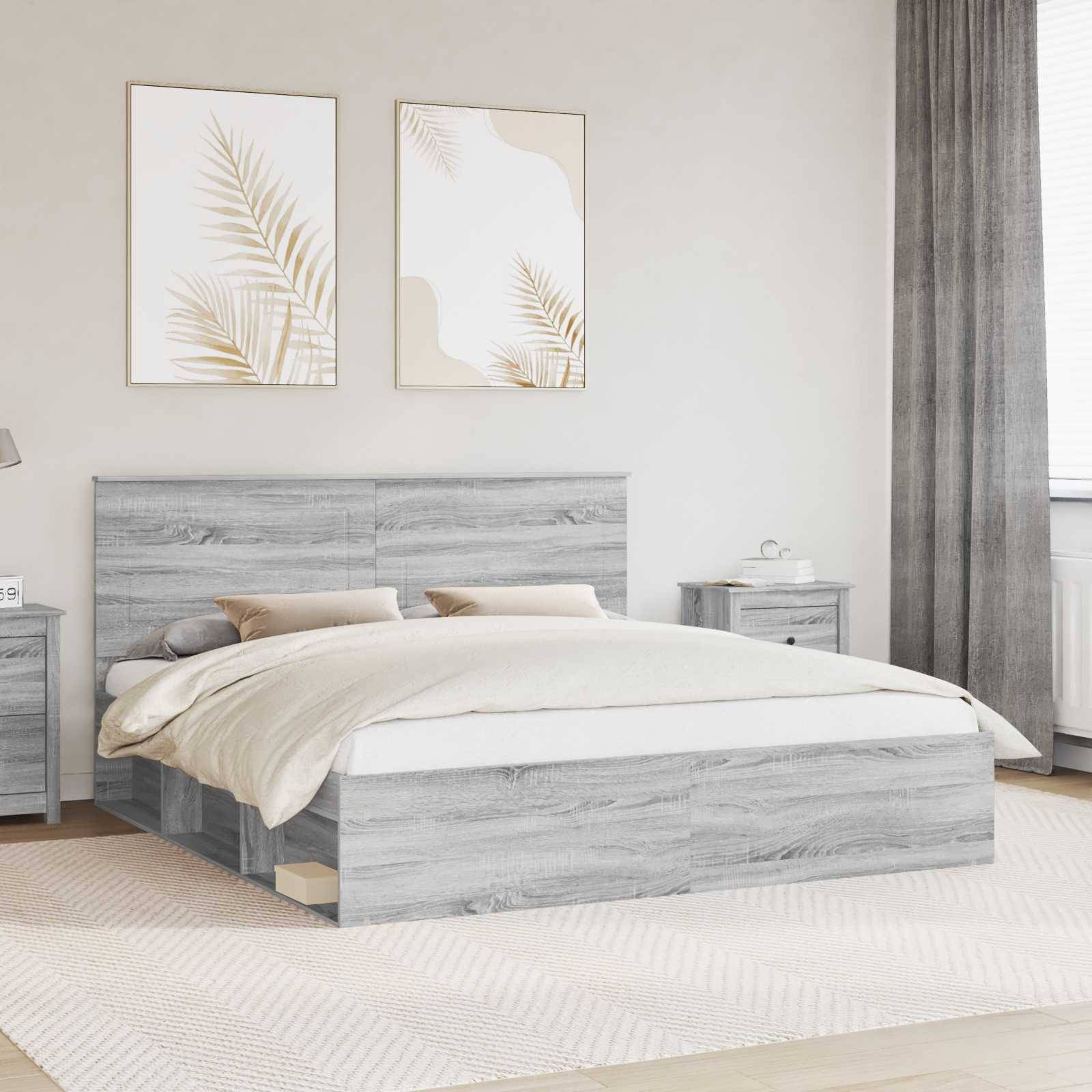 Ein modernes Schlafzimmer zeigt ein graues Holzbett mit zwei Kissen und einer beigen Bettdecke. Zwei abstrakte Blattkunstwerke hängen über dem Kopfteil.