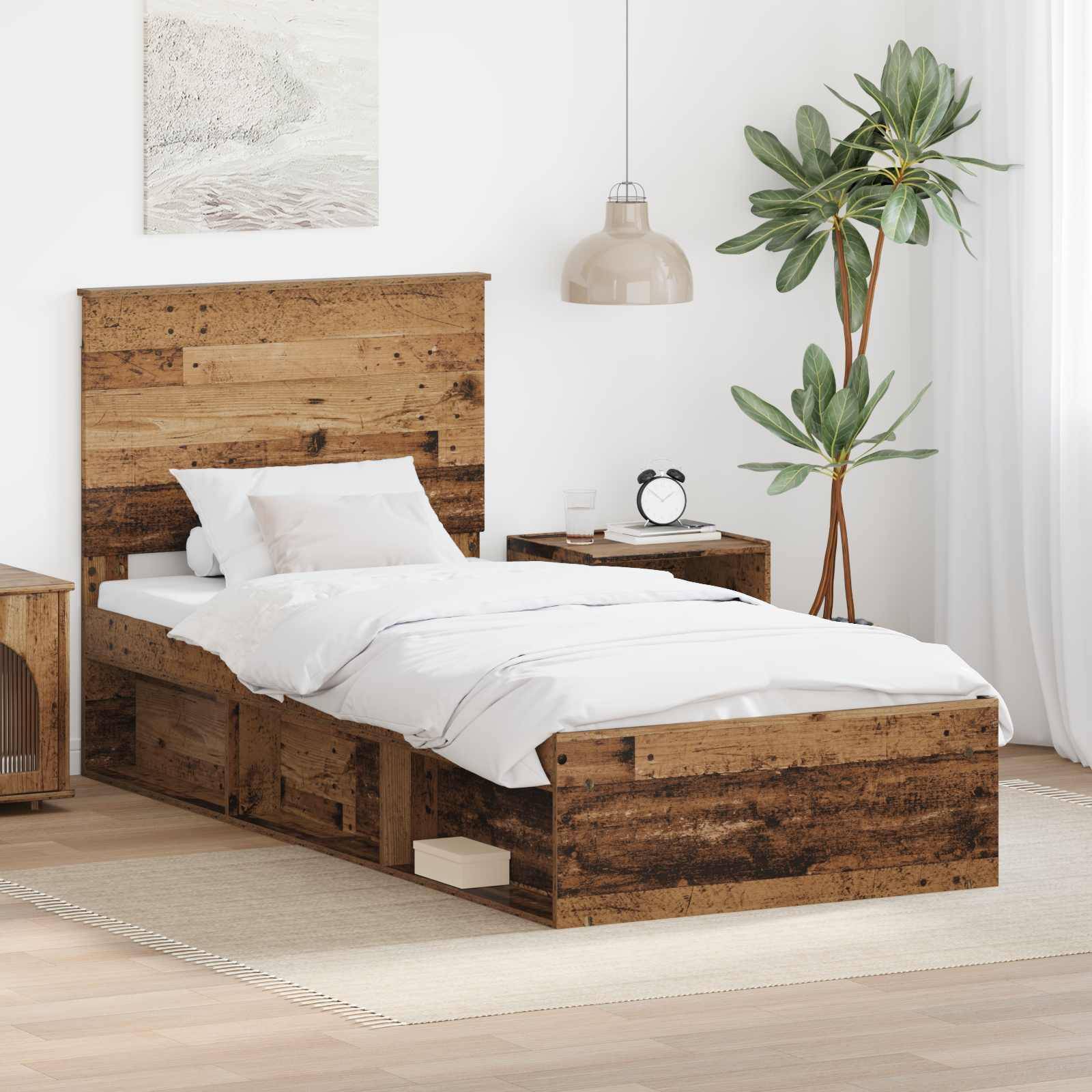 Ein Schlafzimmer mit einem Holzbett mit Aufbewahrungsschubladen, weißer Bettwäsche, einem Nachttisch mit einer Lampe und einer Uhr sowie einer hohen Pflanze in der Nähe.