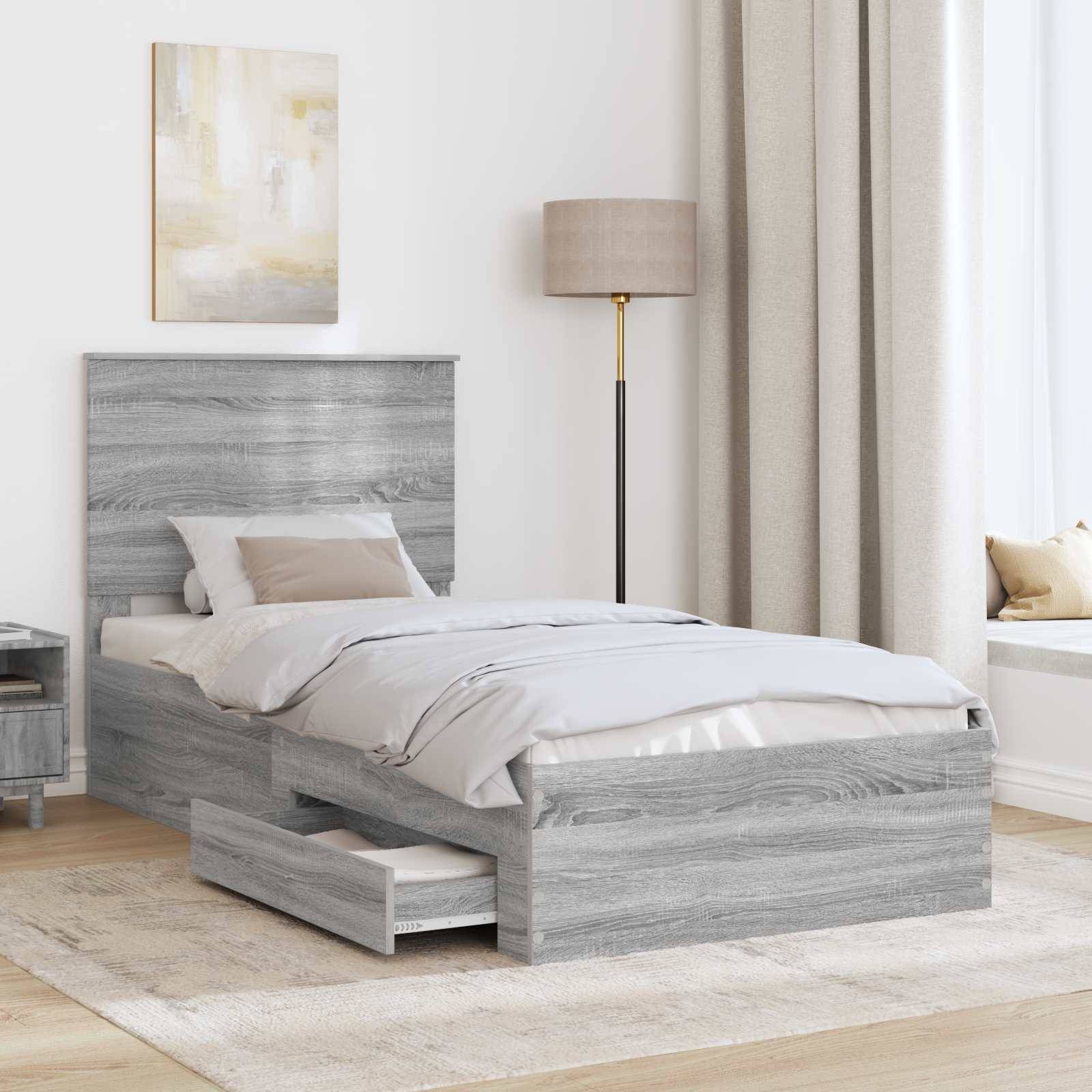 Ein modernes Schlafzimmer mit einem grauen Holzbett mit Schubladen zum Verstauen, einer beigen Lampe und einem leichten Vorhang. Ein gerahmtes abstraktes Gemälde hängt darüber.