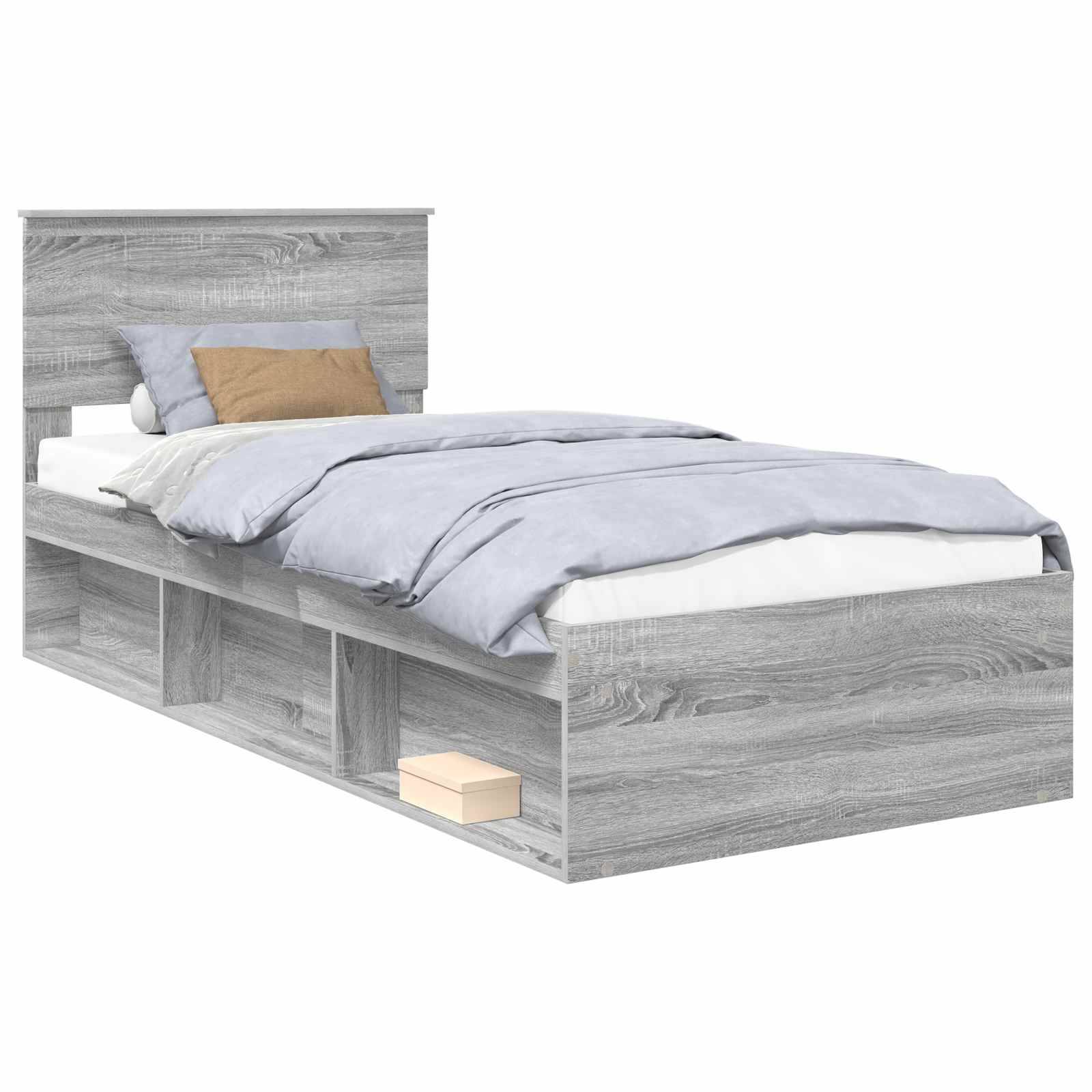 Ein Einzelbett mit einem hellgrauen Holzrahmen, der integrierte Stauraummöglichkeiten unter dem Bett aufweist, und mit blau-weißer Bettwäsche bezogen.