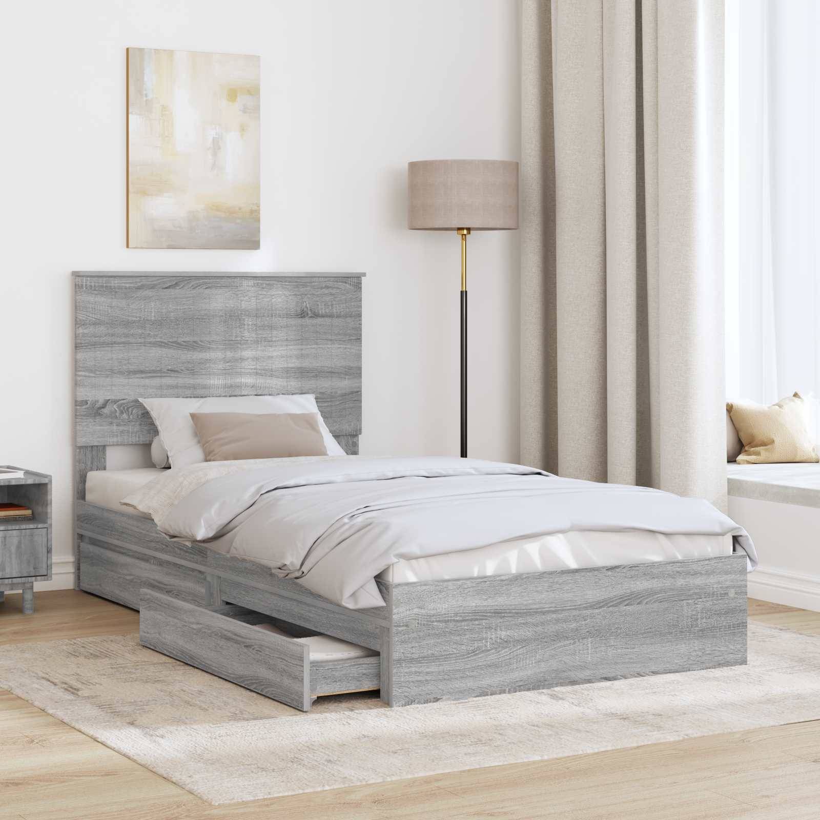 Ein modernes Schlafzimmer verfügt über ein hellgraues Holzbett mit Schubladen zum Verstauen, einen passenden Nachttisch, beigefarbige Bettwäsche, eine hohe Stehlampe und abstrakte Wandkunst.