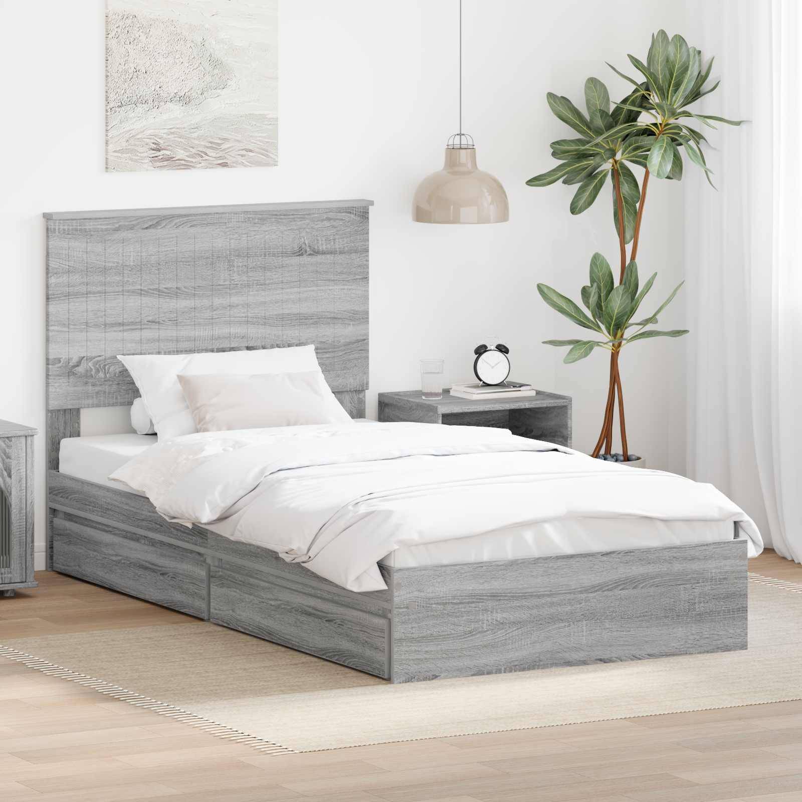 Ein modernes Schlafzimmer mit einem grauen Holzbett, weißer Bettwäsche, einem Nachttisch, einer hängenden Lampe und einer grünen Pflanze in der Ecke.