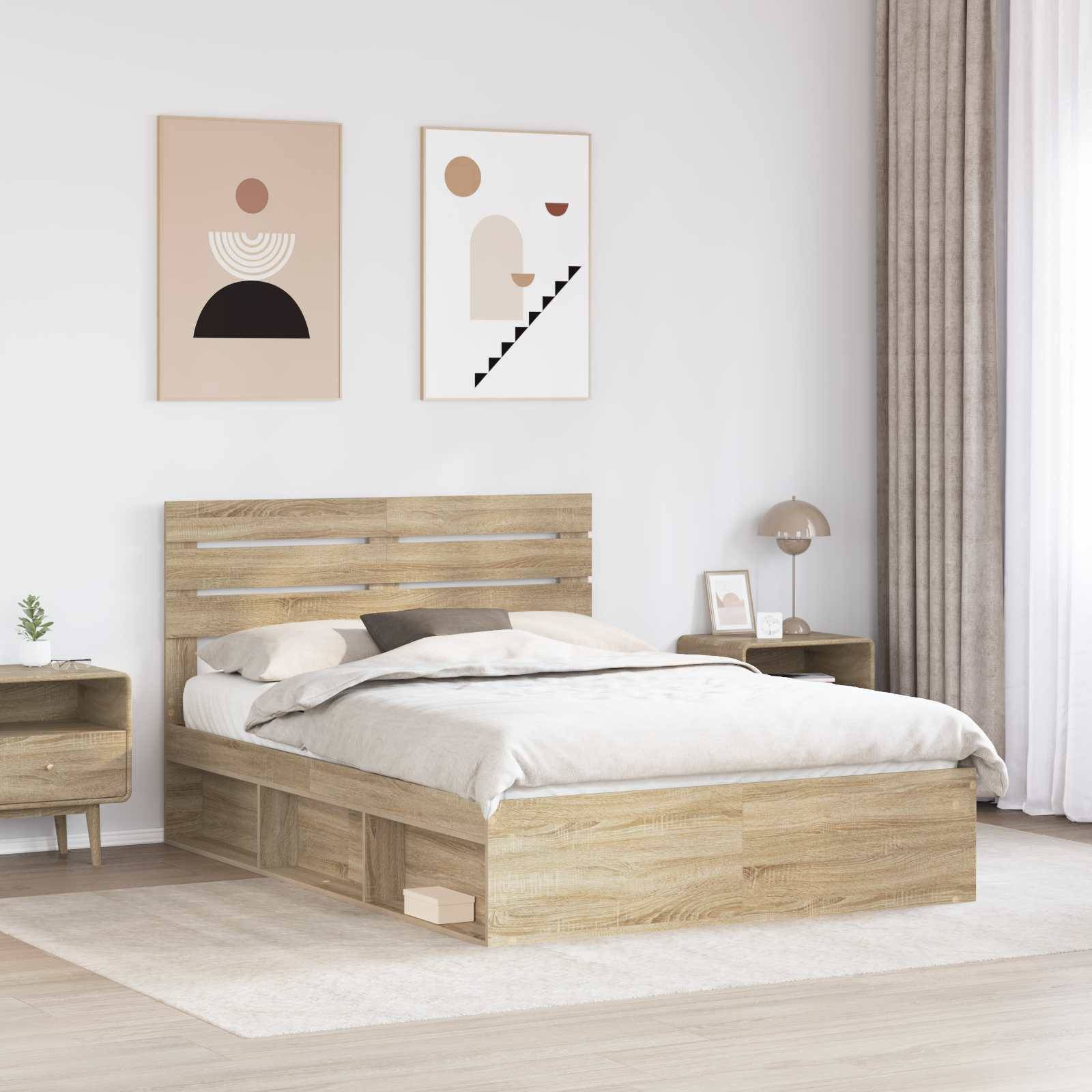 Ein modernes Schlafzimmer mit einem Holzbett mit einer hellgrauen Steppdecke, zwei minimalistische Kunstwerke darüber und einem Nachttisch mit einer Lampe.