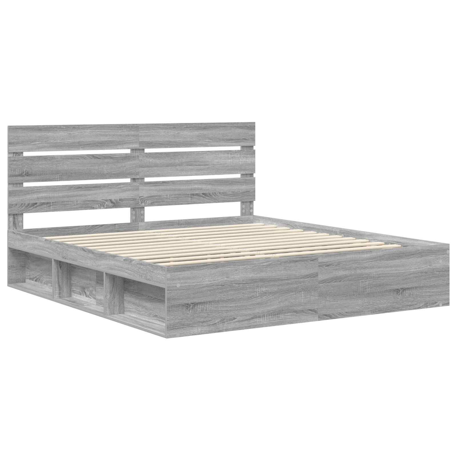 Ein Bettgestell aus Holz mit einem lamelliertem Kopfteil und offenen Stauraumfächern darunter, gefertigt aus hellgrauem Holz.