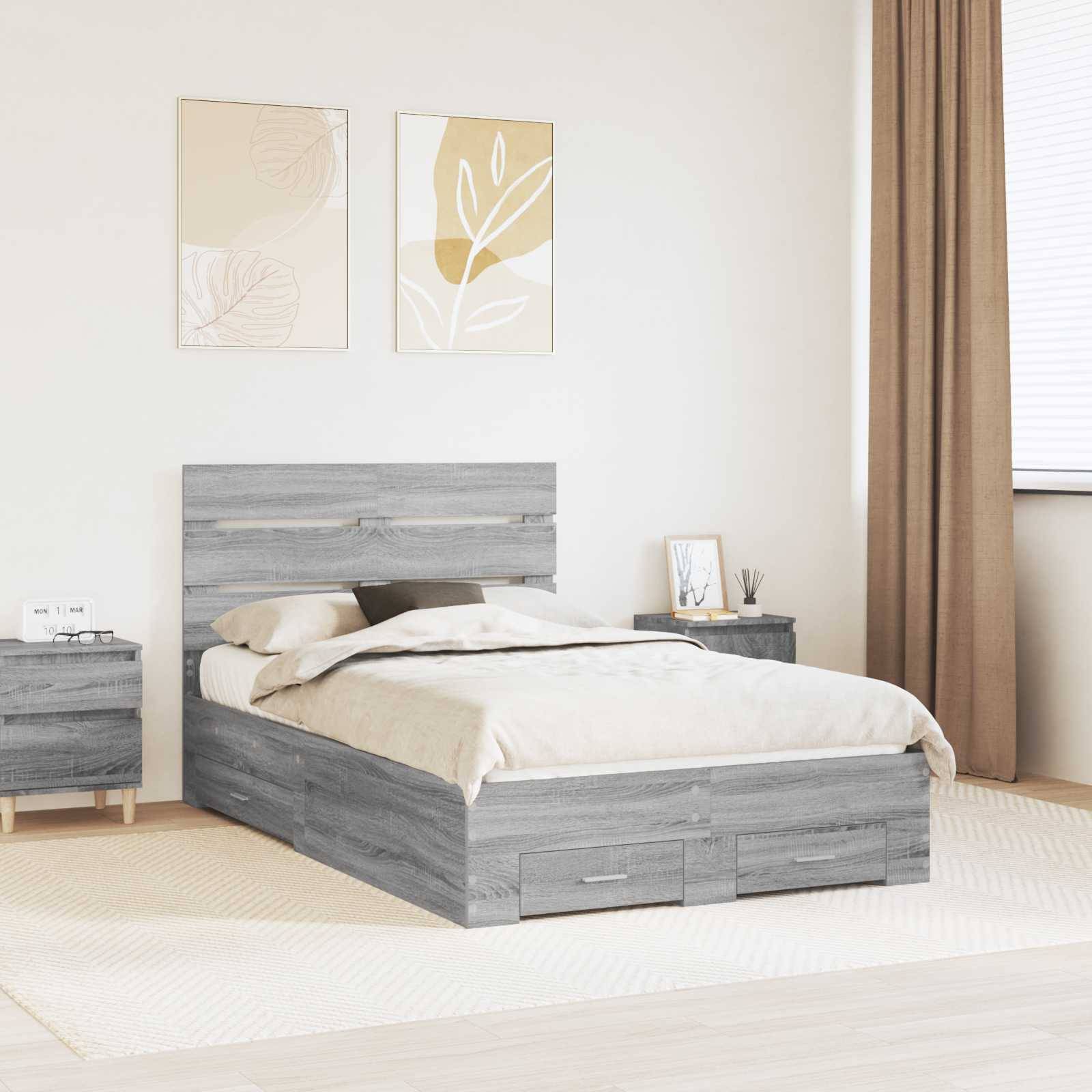 Ein Schlafzimmer zeigt ein graues Holzbett mit Staurageschubladen, passenden Nachttischen und minimalistischer, pflanzenthematischer Wandkunst in einem sanft beleuchteten Raum.