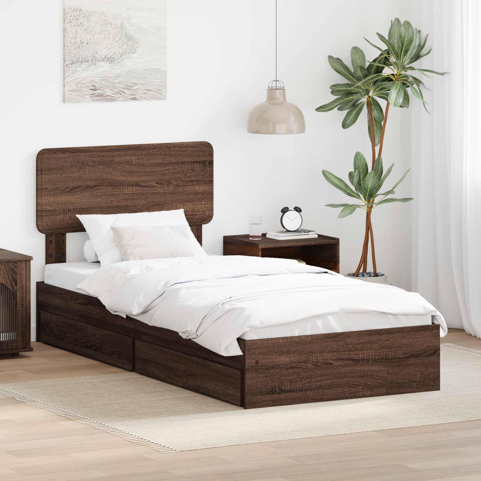 Schlafzimmer mit einem Holzbett, weißer Bettwäsche, einem Nachttisch, einer Lampe und einer Pflanze. Helle Wände schaffen eine ruhige Atmosphäre.