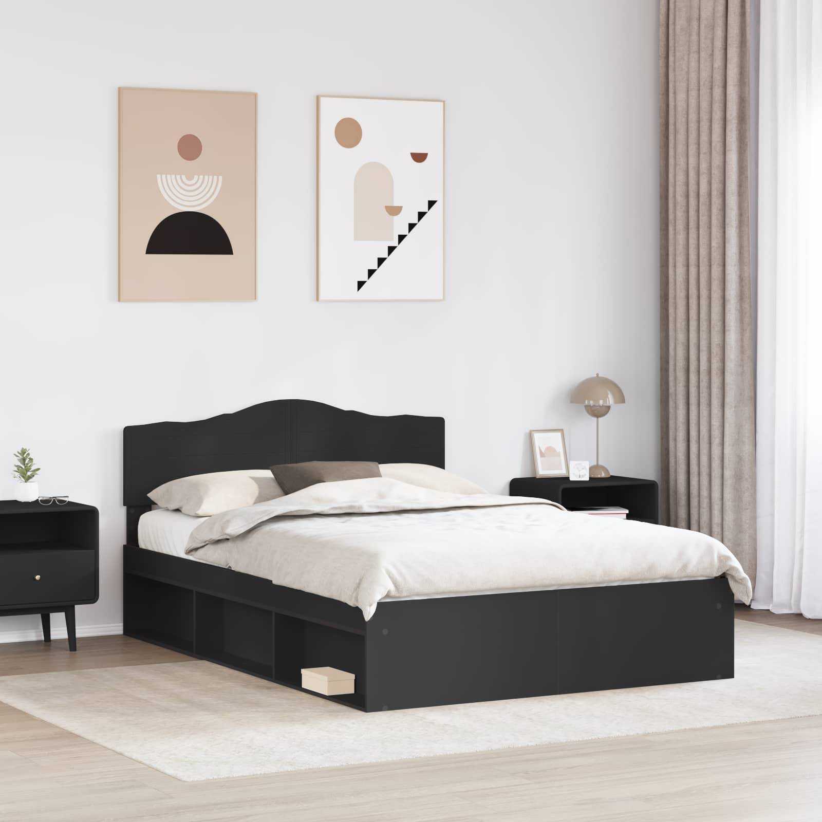 Ein modernes Schlafzimmer mit einem schwarzen Bett mit Unterbettstauraum, einem Nachttisch, einer Lampe und abstrakter Kunst an einer weißen Wand.