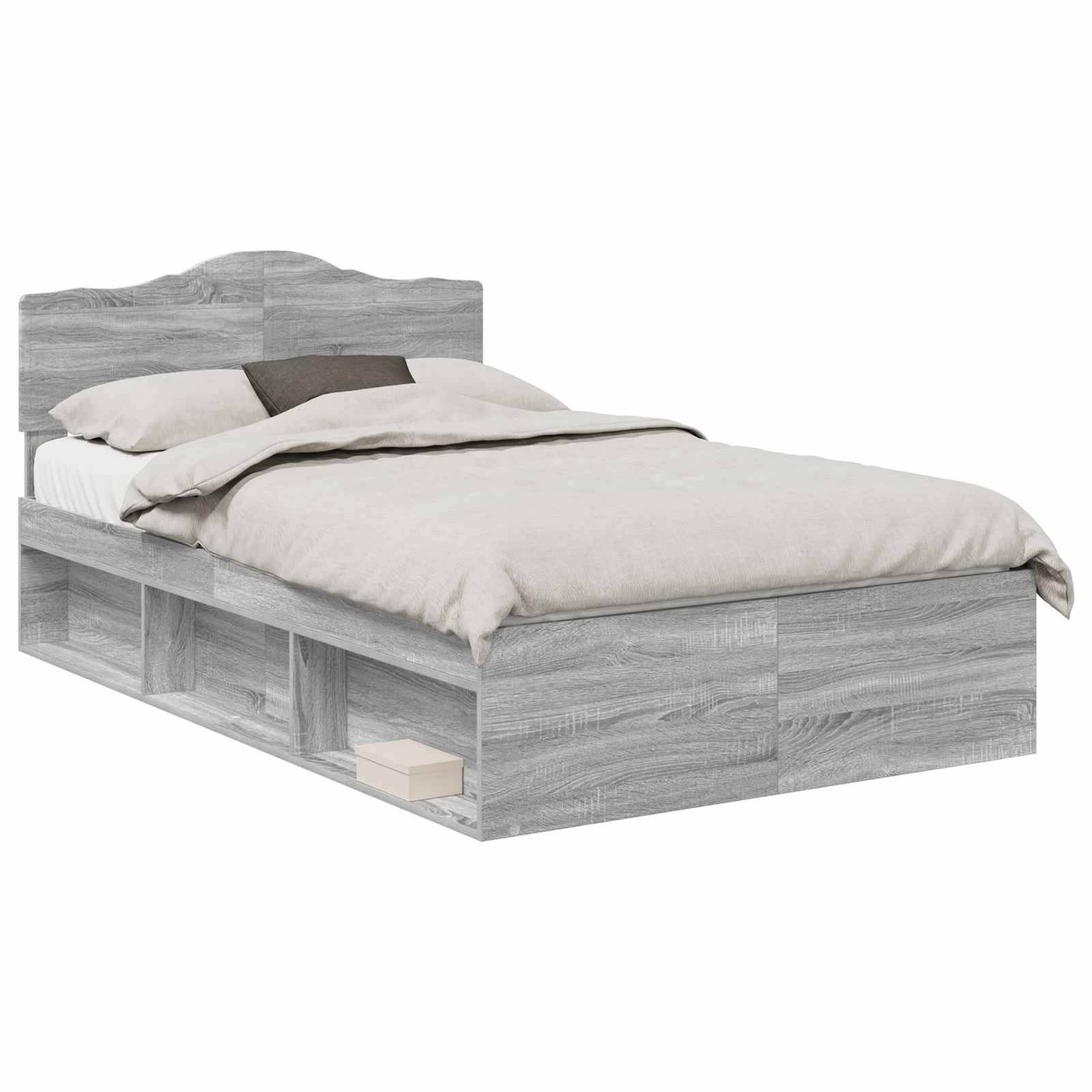 Ein Holzbettgestell mit grauer Beschichtung ist mit einer beigen Decke und einem dunklen Kissen ausgestattet. Stauraummöglichkeiten sind unter dem Bett sichtbar.